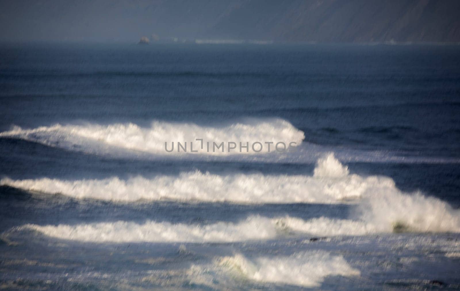 Powerful waves crash upon the beach alog the Pacific Ocean at Big Sur, Californias