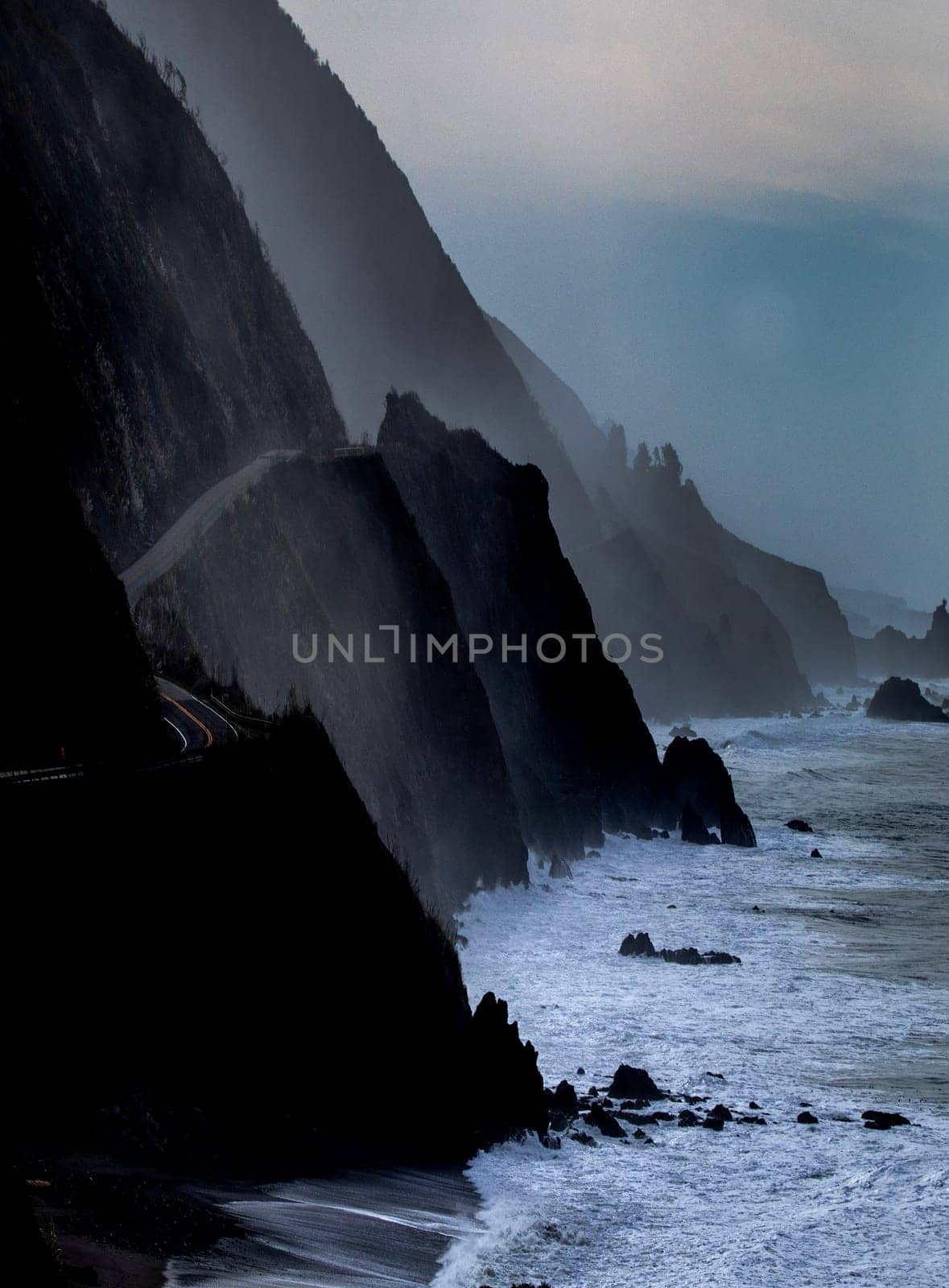 Powerful waves crash upon the beach along Pacific Coast Highway at the Pacific Ocean at Big Sur, California.