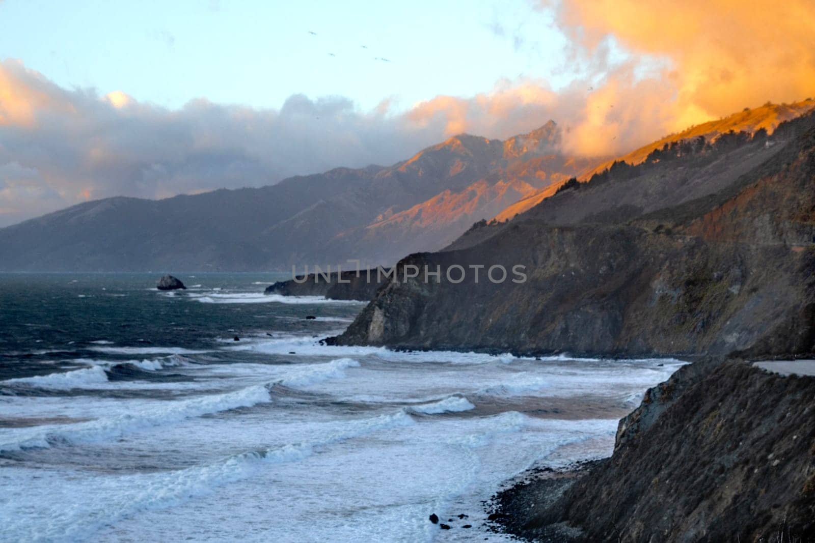 Powerful waves crash upon the beach alog the Pacific Ocean at Big Sur, Californias