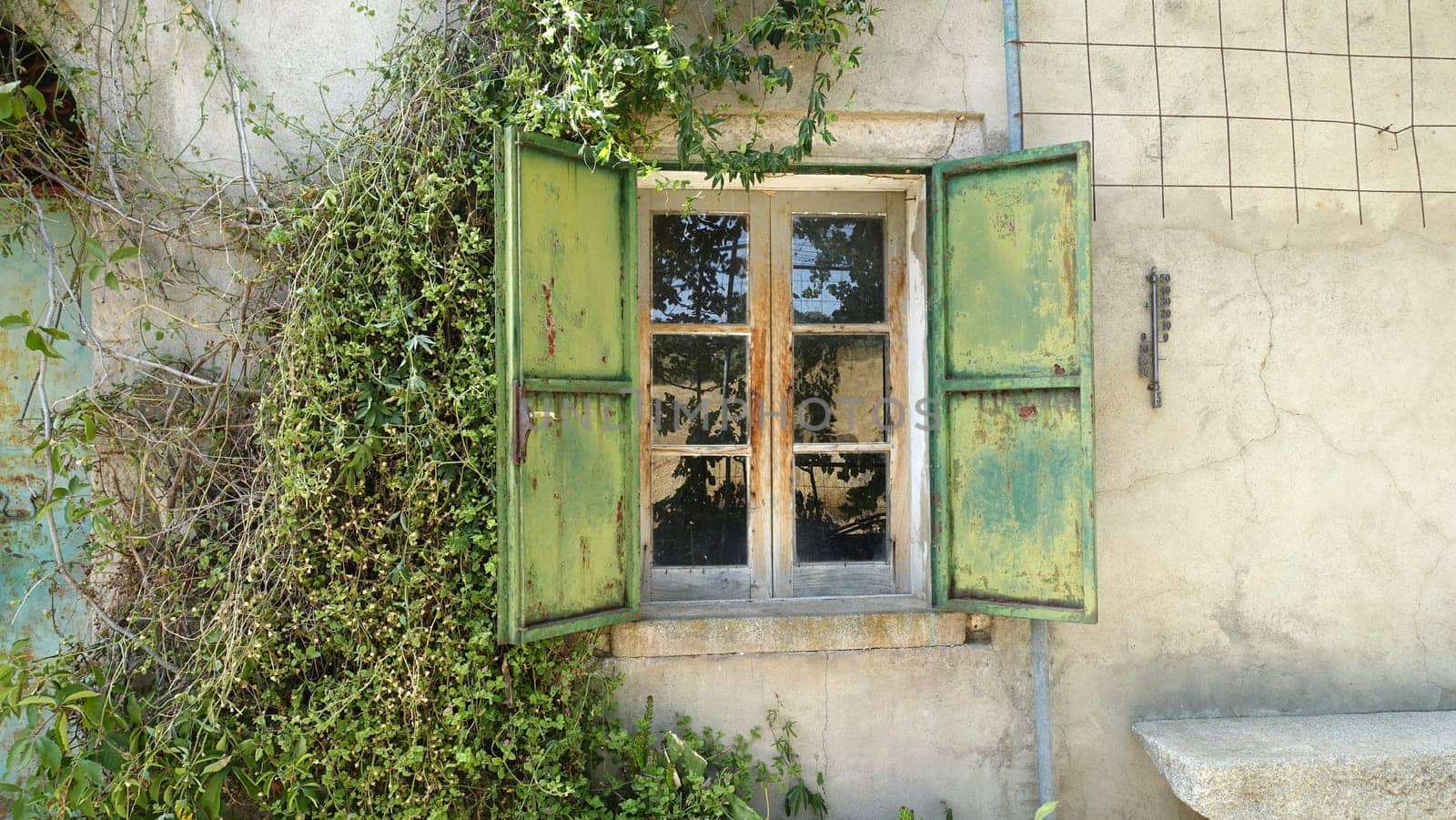 The window with metal shutters of an ancient house in the countryside. by Jamaladeen
