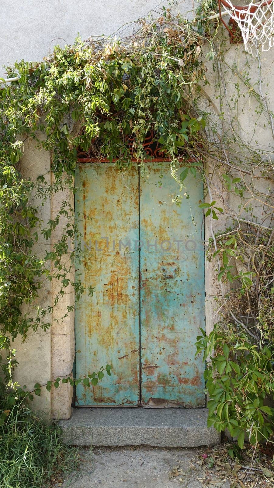 The door with metal swings of an ancient house in the countryside. by Jamaladeen