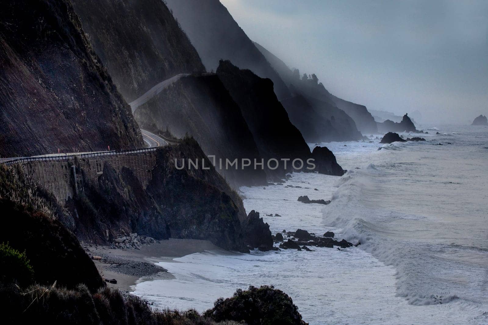 Powerful waves crash upon the beach along Pacific Coast Highway at the Pacific Ocean at Big Sur, California.
