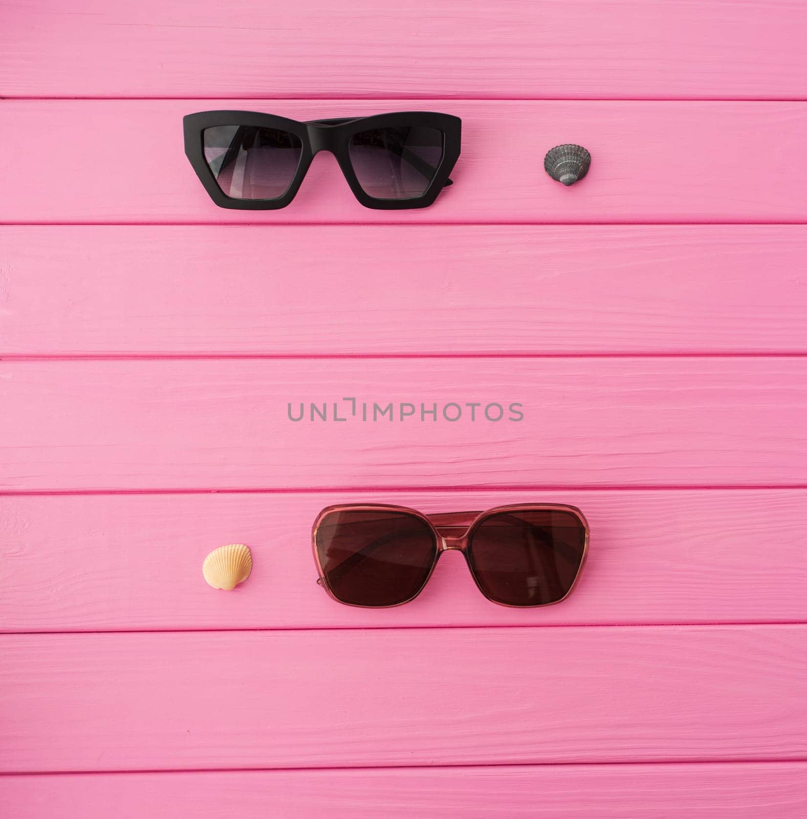 Summer abstract background mockup template free copy space for text pattern sample top view above on pink wooden board. blank empty area for inscription. Stylish sunglasses fashionable with seashells