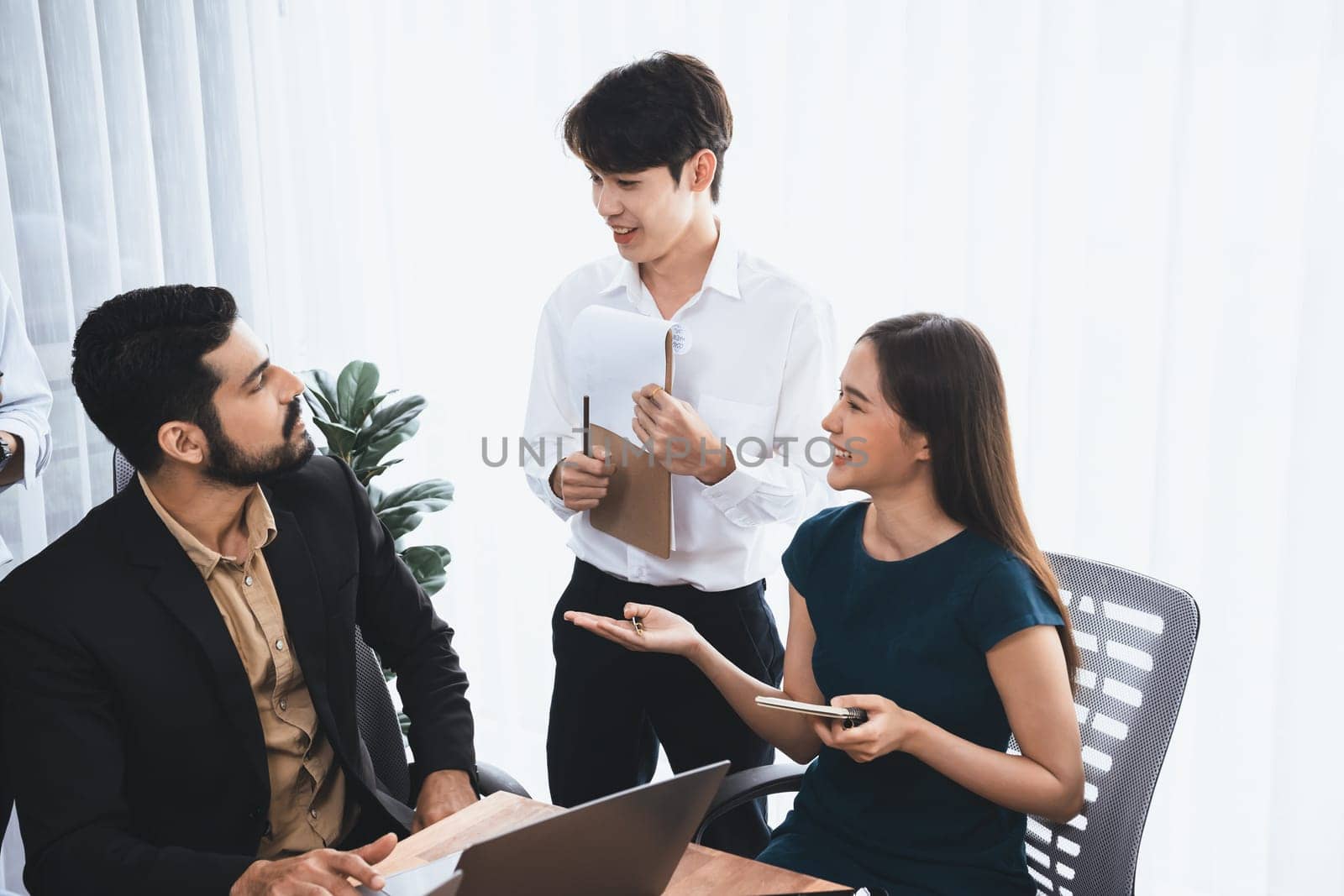 Professional Asian employee work together as team in corporate office, discussing business plans and data to achieve success on desk with laptop. Modern office worker teamwork concept. Concord