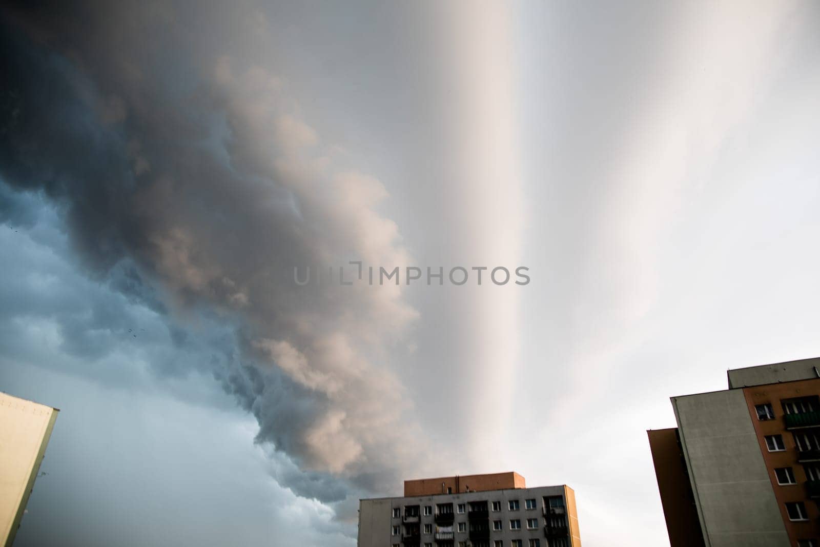 A local hurricane rages over city skyscrapers. The sky is covered with clouds.