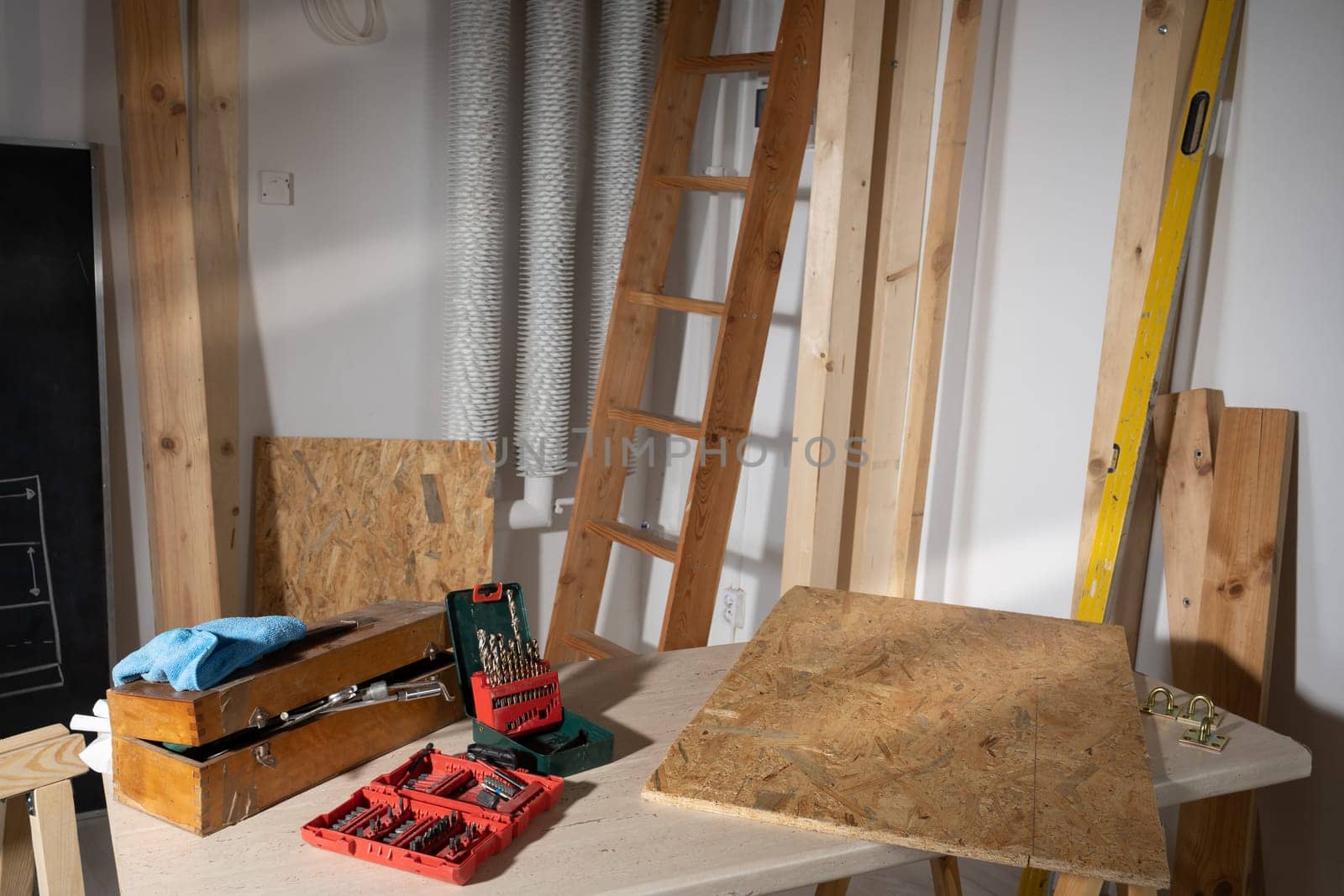 Wooden table top. Set of metal drill bits. A set of bits for screwing in various types of bolts and screws.