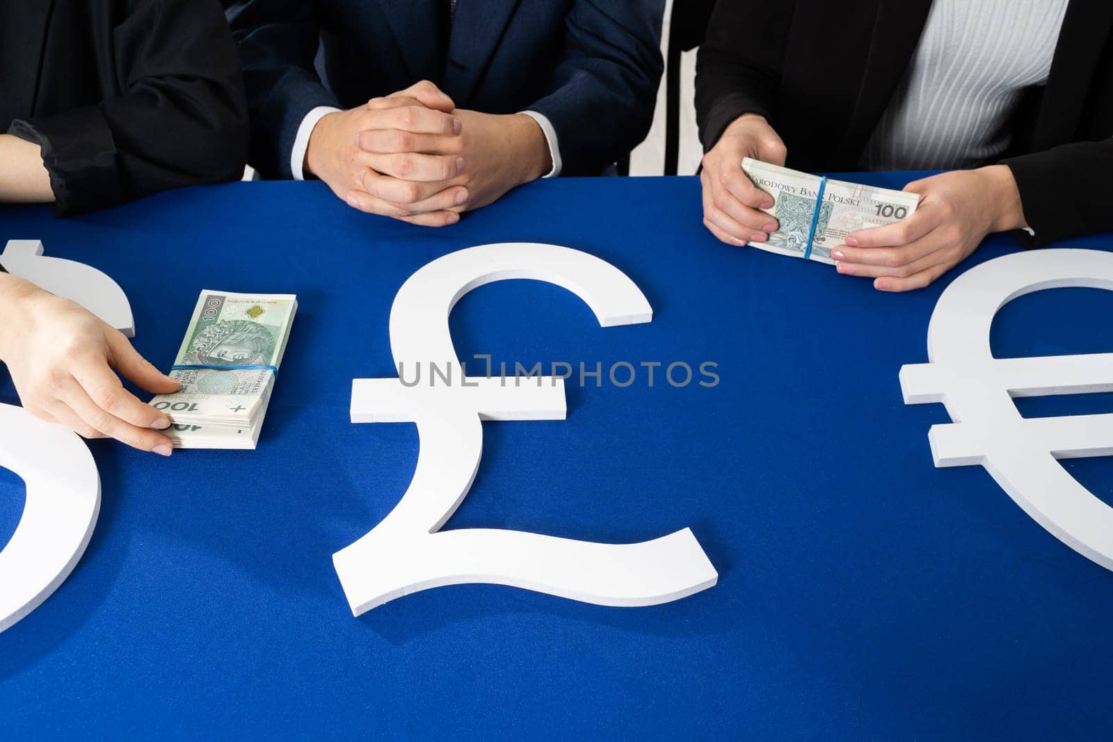 The three-person commission divides the money intended for the needy. On the blue table lie bundles of banknotes in the face value of one hundred Polish zlotys.