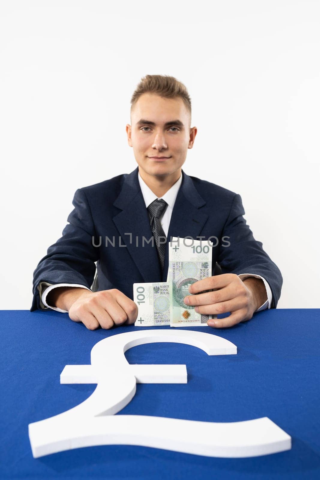 Smiling young adult at the currency service counter of a national bank. A gifted boy in a responsible position.