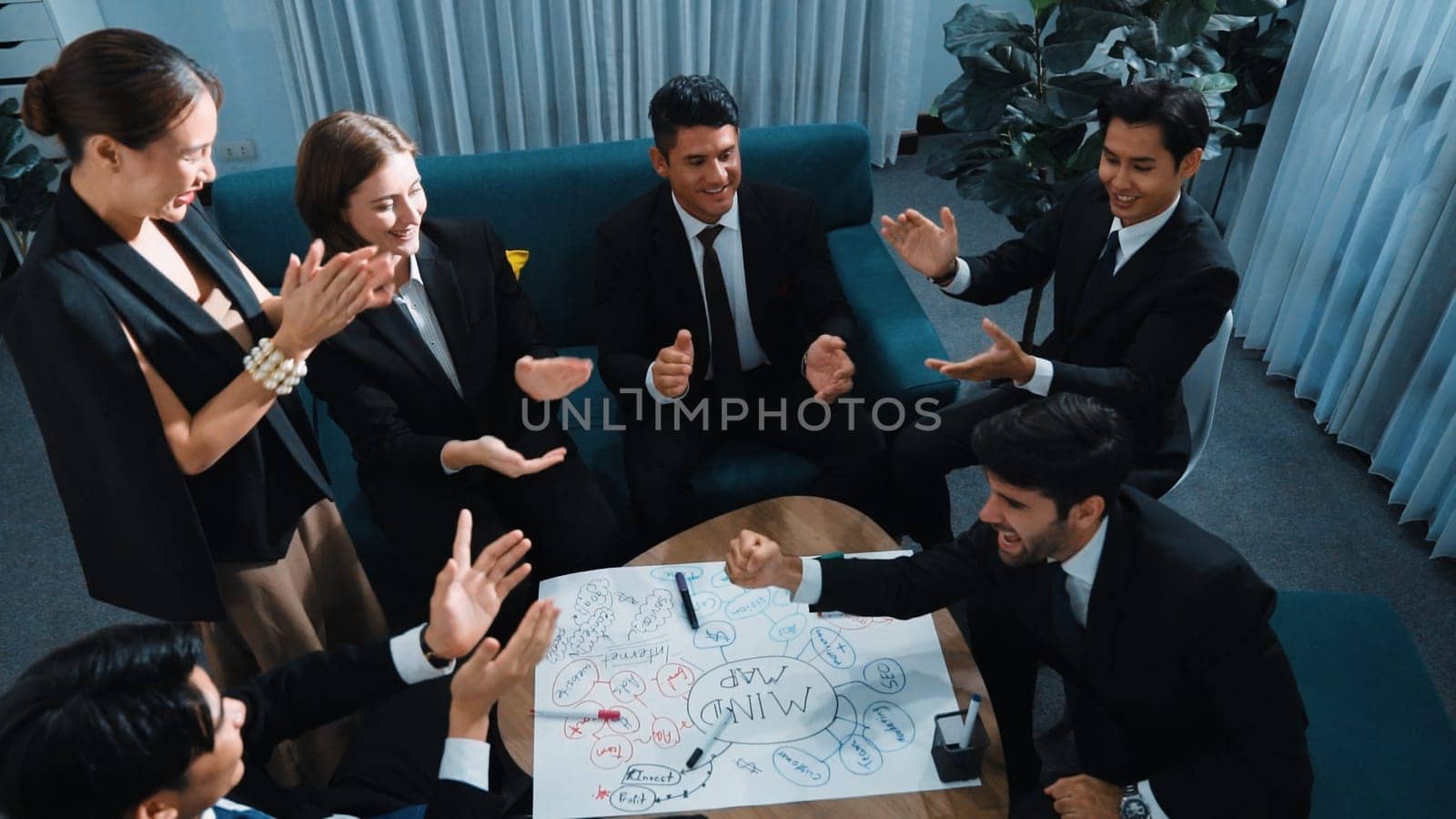 Top view of business people clapping hands to celebrate successful project while using mind map to brainstorm idea. Happy team clap handor applause successful plan while writing mind map. Directorate.