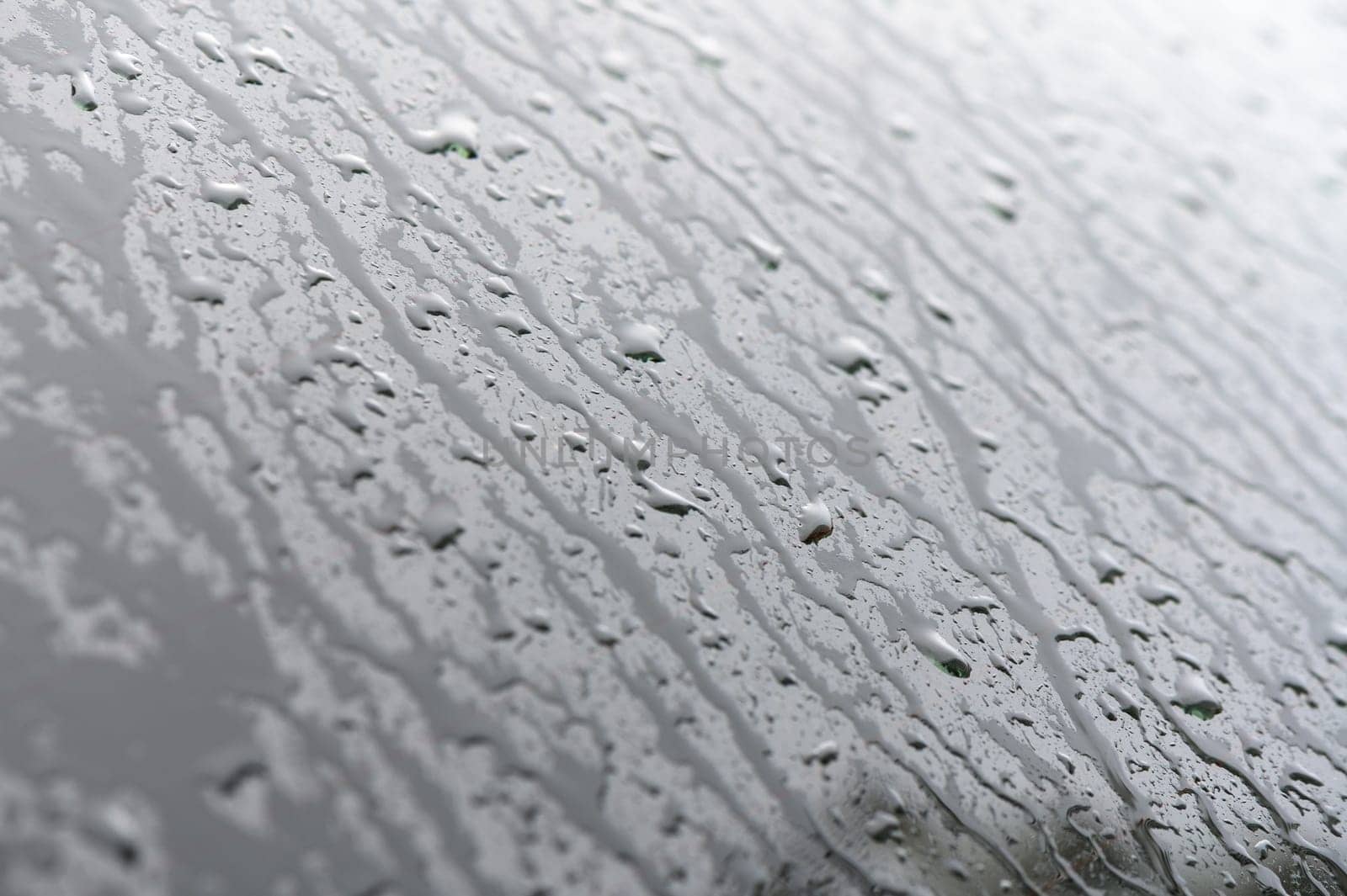 Raindrops on the side window of a car on an autumn day 1
