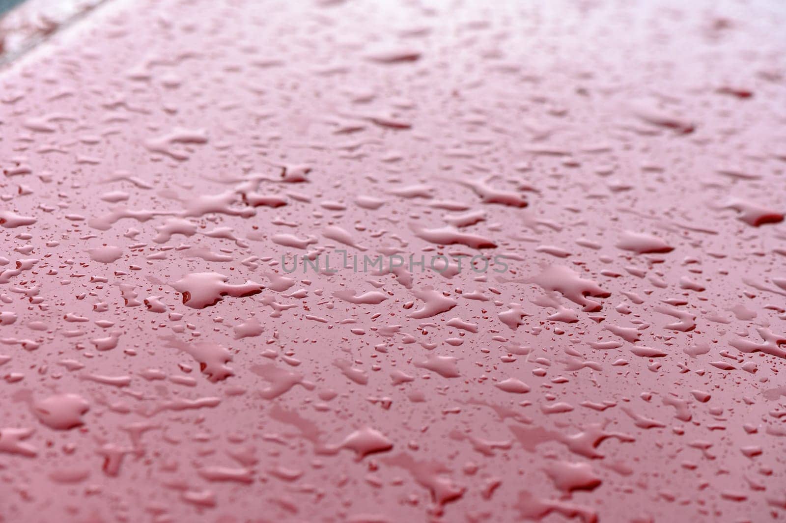 Closeup rain drops on red car 1