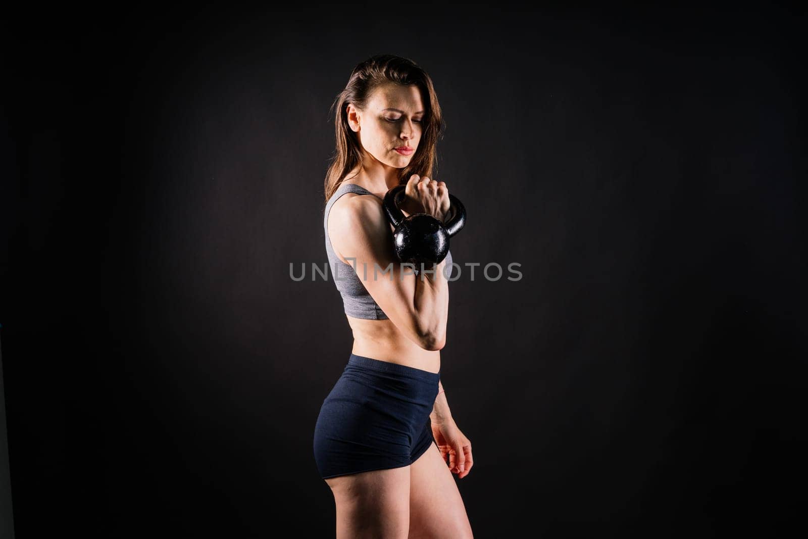 Young female doing swing exercise with a kettle bell. Fitness woman by Zelenin