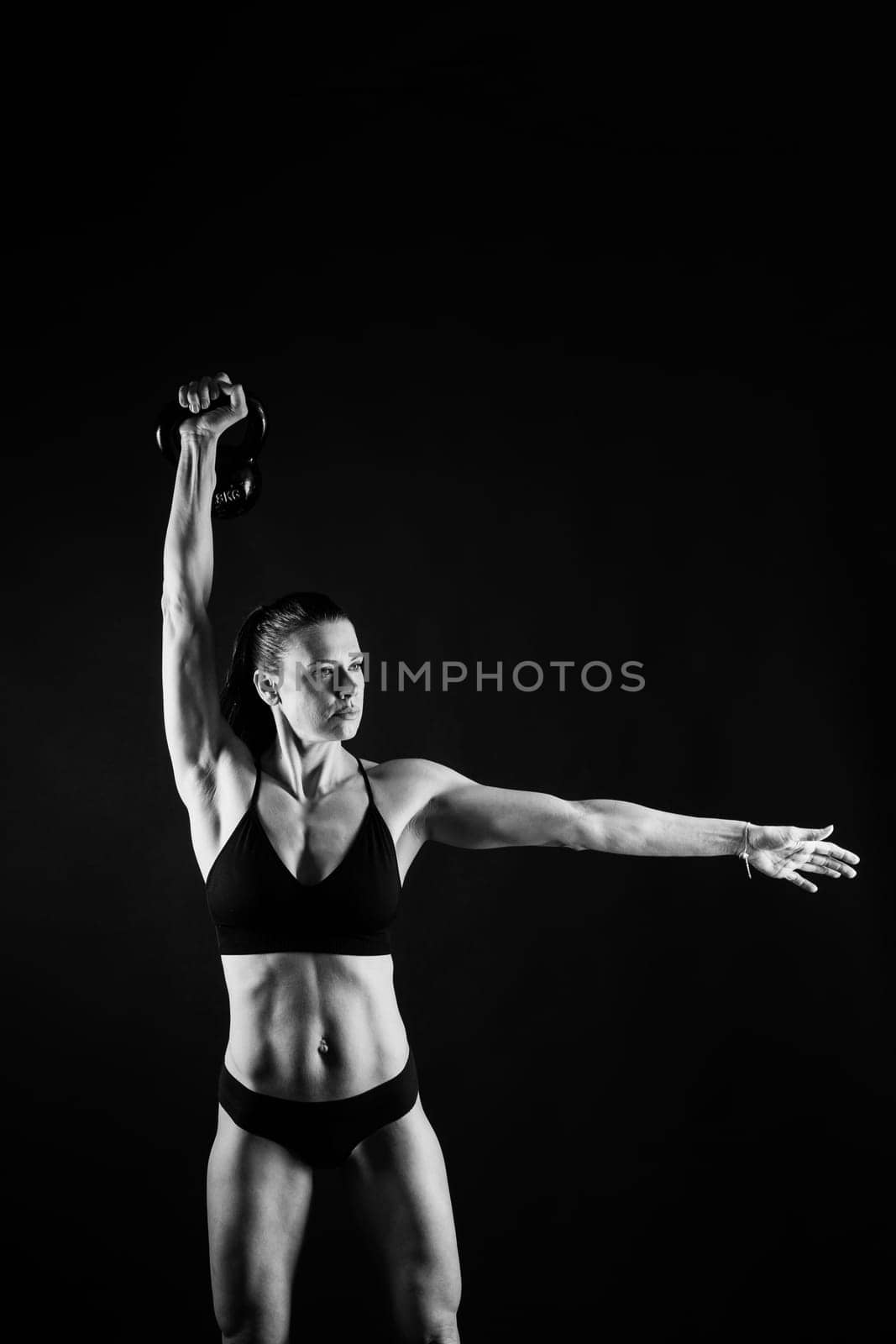 Young female doing swing exercise with kettle bell. Fitness woman