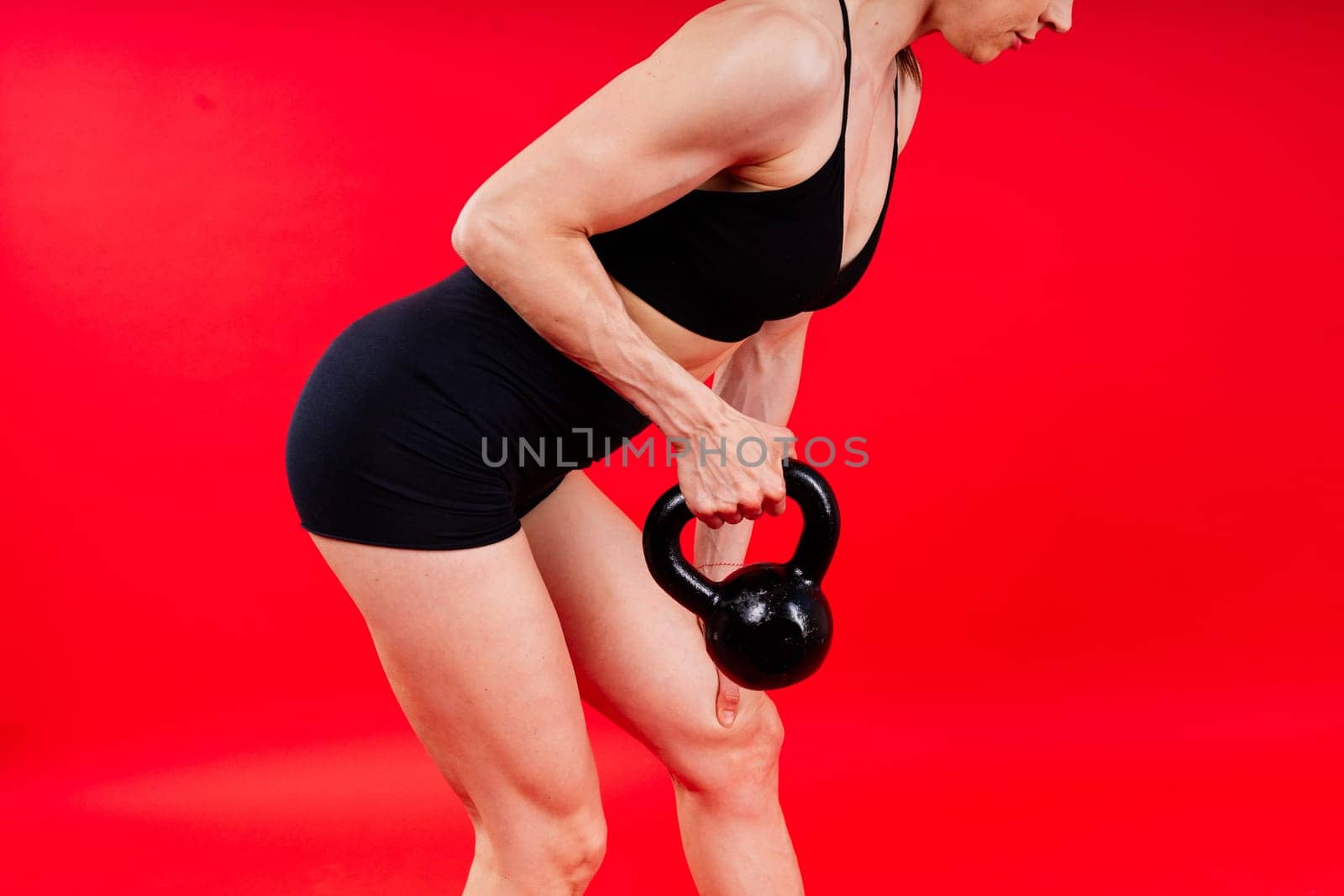 Young female doing swing exercise with kettle bell. Fitness woman