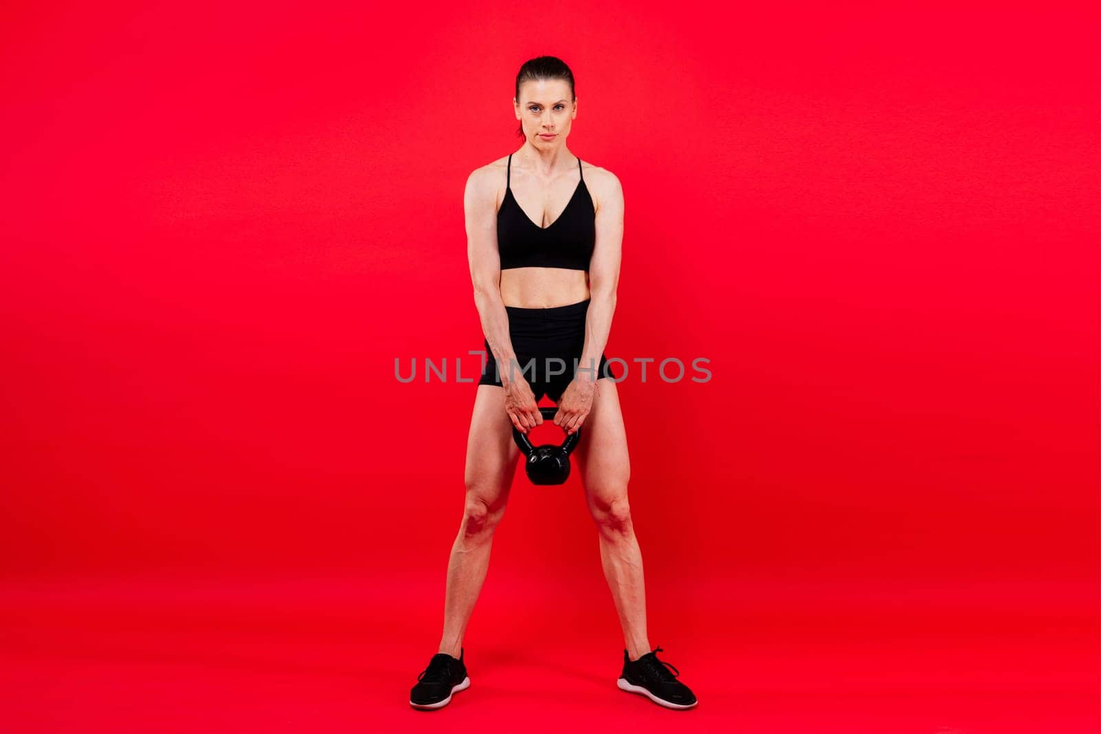 Young female doing swing exercise with a kettle bell. Fitness woman by Zelenin