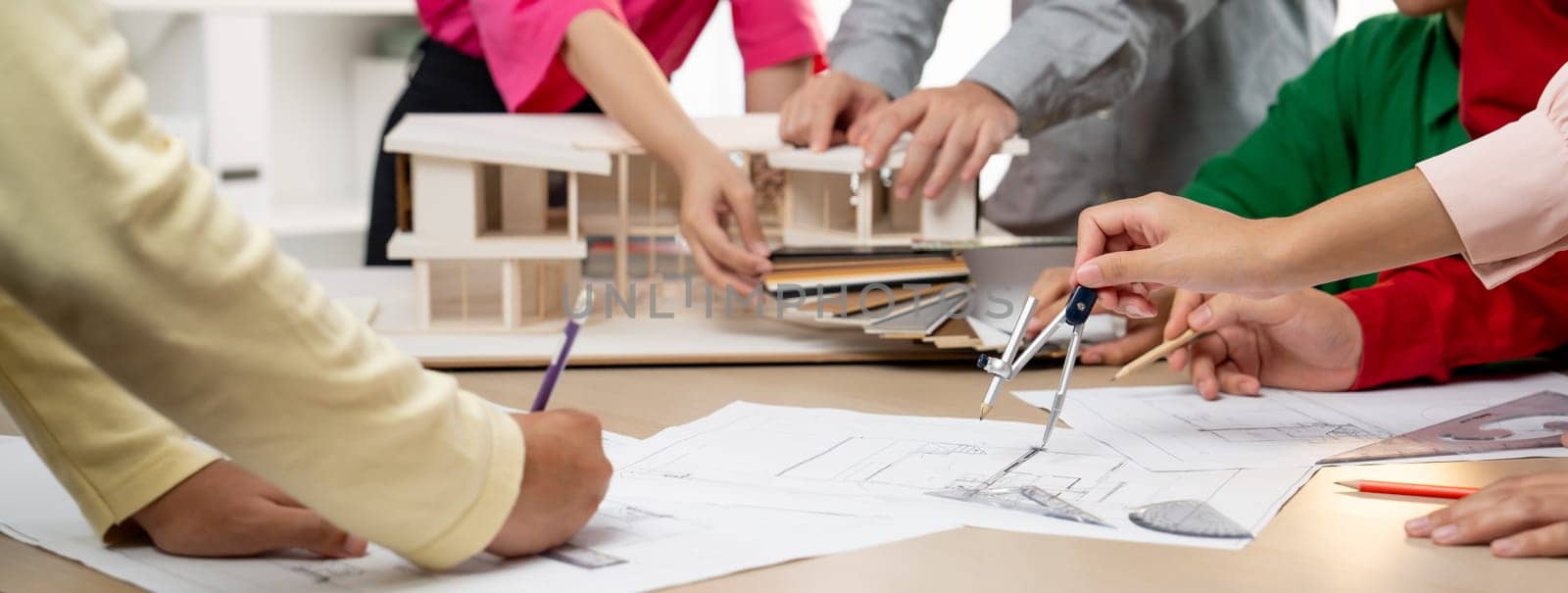 Professional architect team select sustainable house materials while skilled engineer using divider measure blueprint with house model and color palette placed on meeting table. Closeup. Variegated.