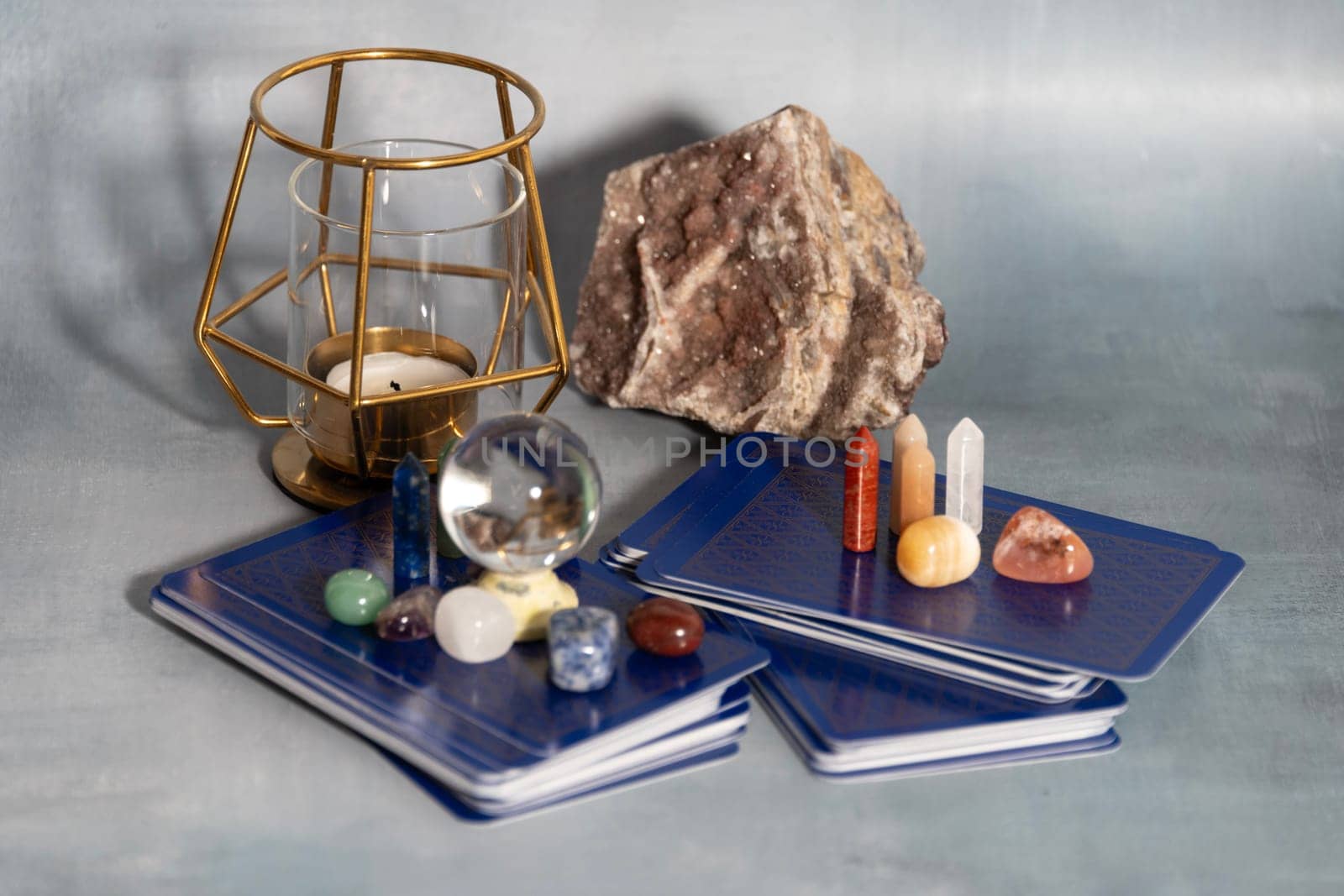 A serene tarot setup featuring a geode, assorted crystals, and a candle holder, creating a tranquil ambiance for spiritual readings