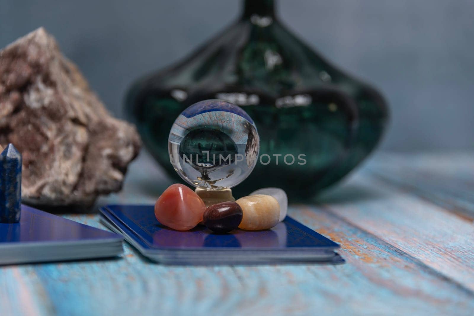 An intimate tarot reading session arrangement featuring vibrant crystals, tarot cards, and a geode on a rustic wooden table. by jbruiz78