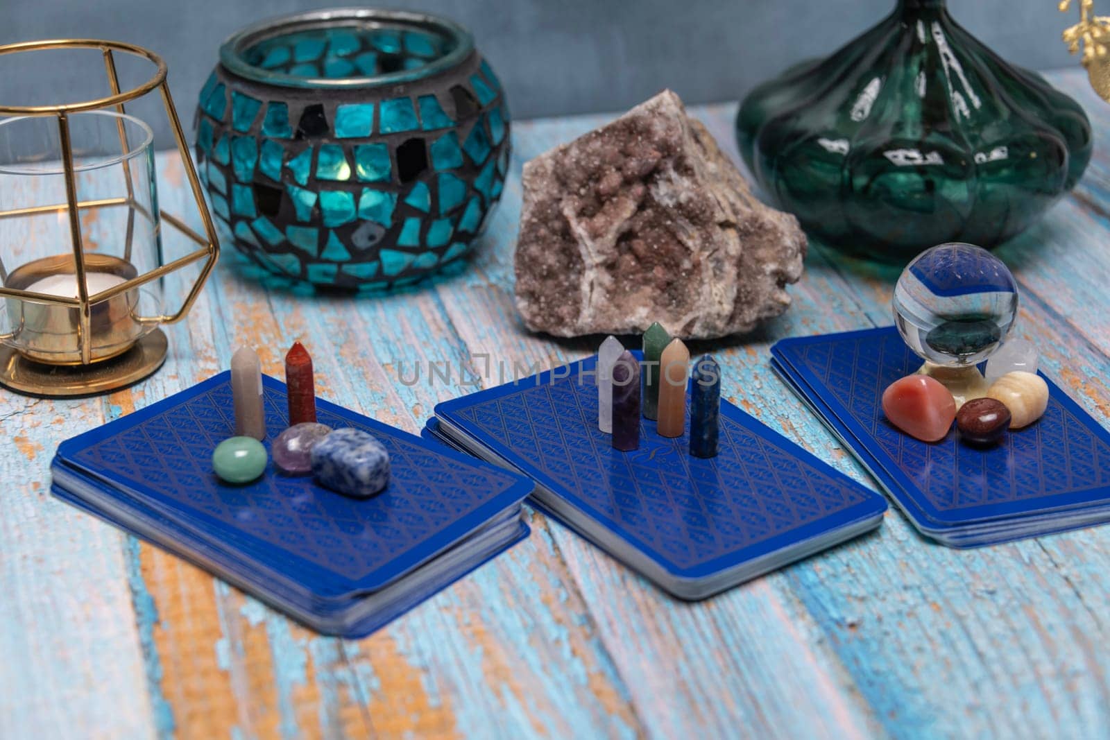 A tarot card reading setup with an array of colorful healing crystals on a weathered wooden table, invoking a sense of mysticism