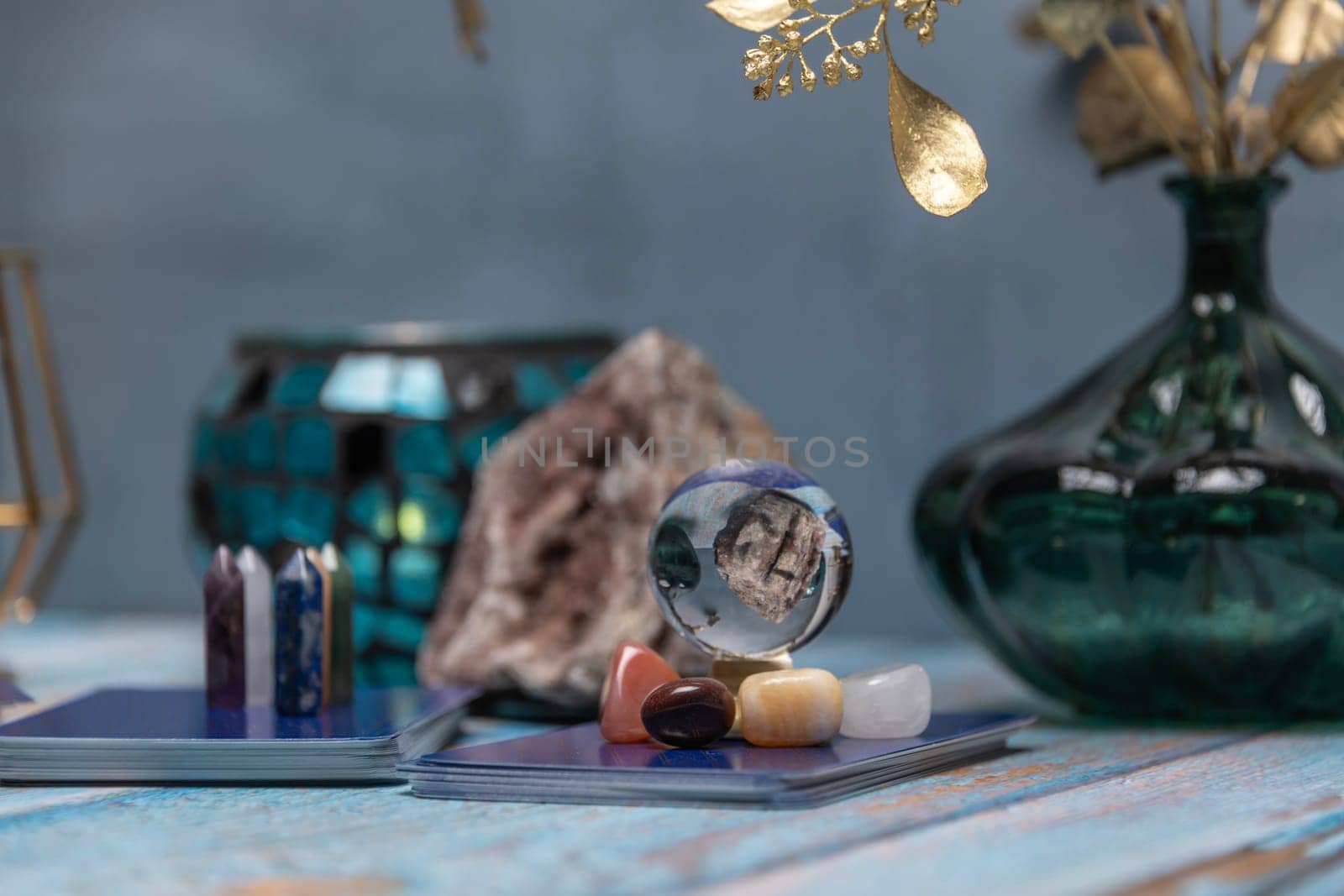 A tarot card reading setup with an array of colorful healing crystals on a weathered wooden table, invoking a sense of mysticism