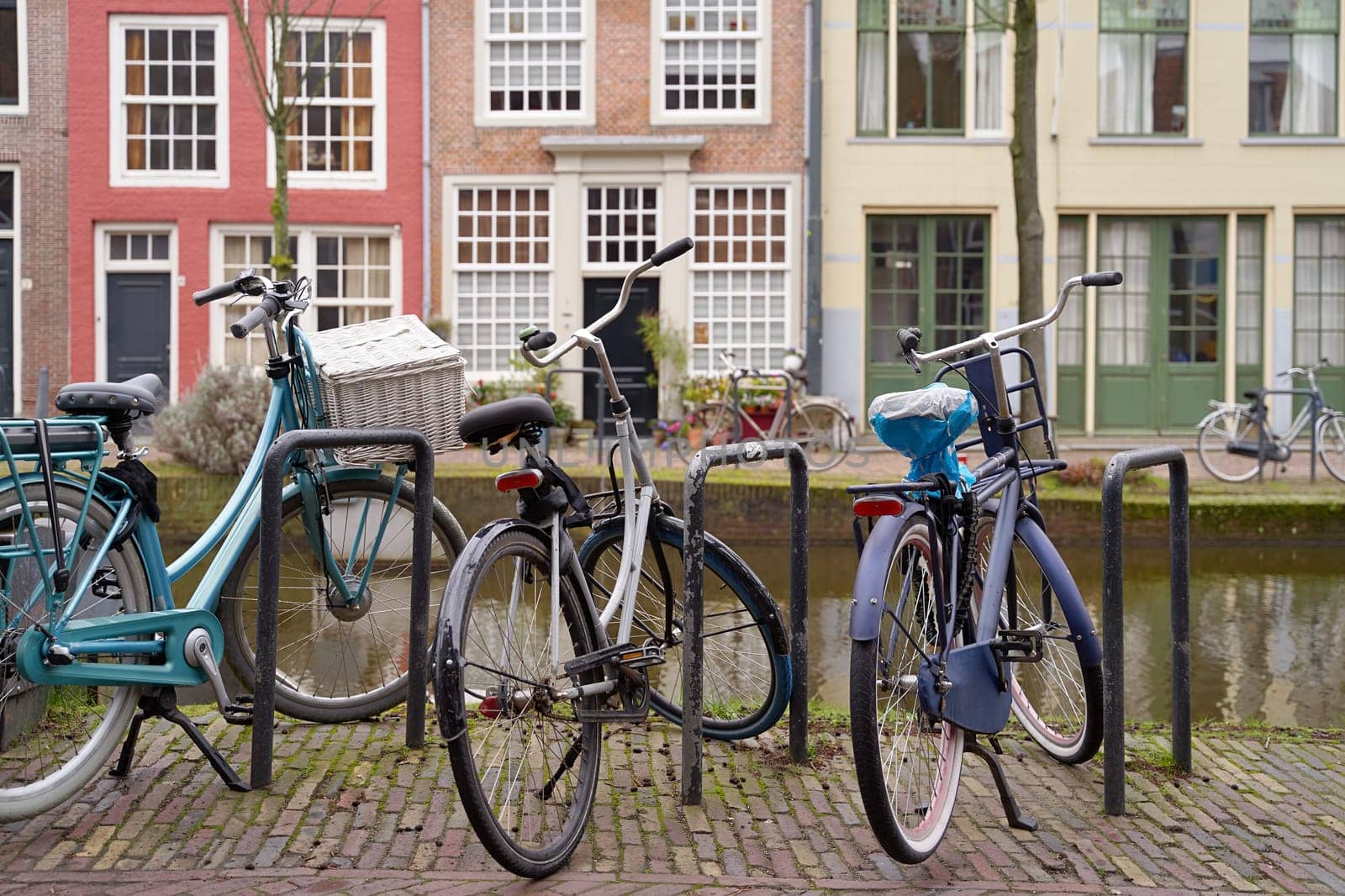 Bicycles parked alongside a channel on beautiful old buildings background.