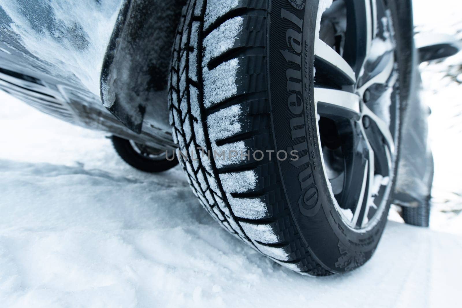 Car with winter tires on snowy road, closeup view by dotshock