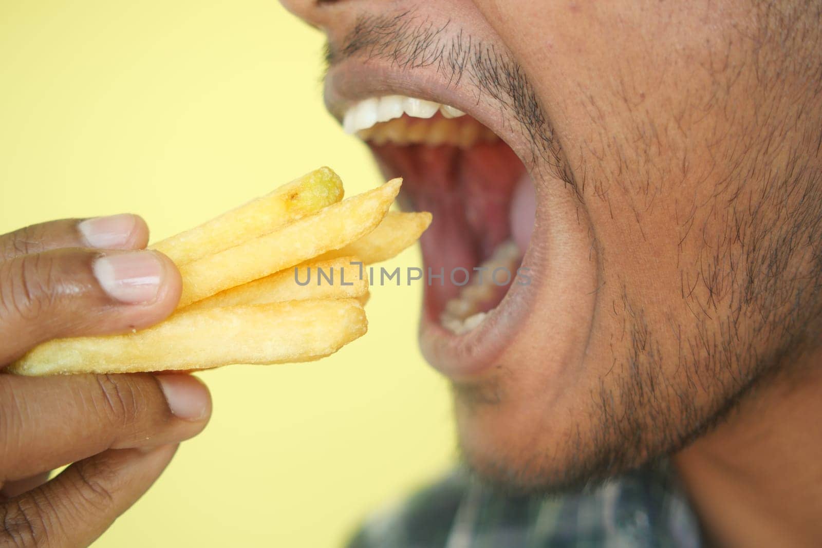hungry man eating fries closeup,