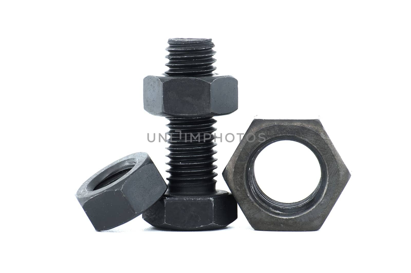 Black metal hexagonal bolt and nut shown in close-up isolated on white background