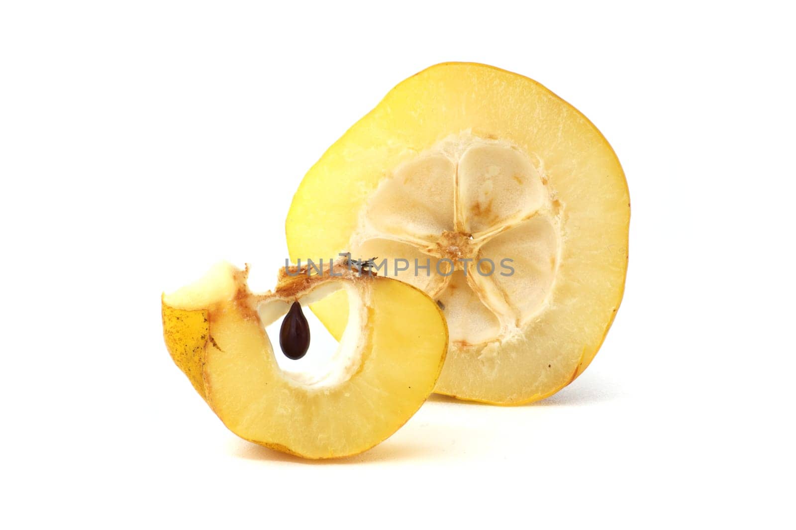 Halved quince with seeds visible over white background by NetPix