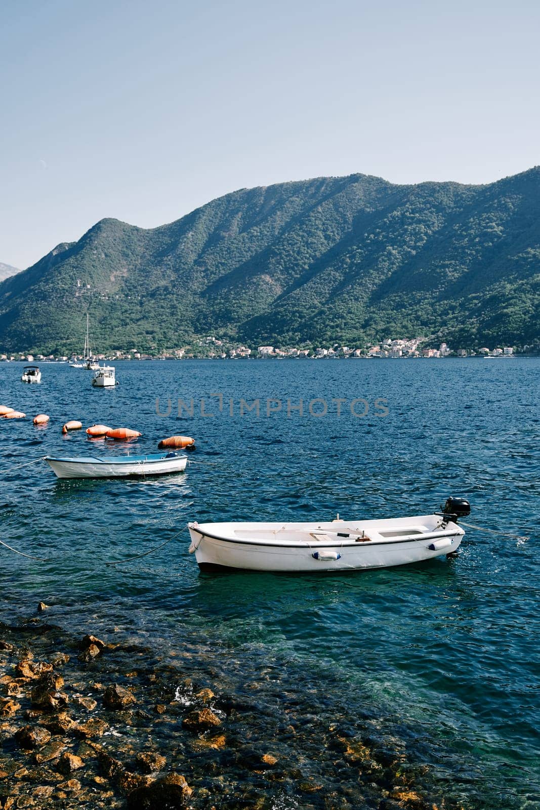 Small motor boats sway on the waves moored near the shore. High quality photo