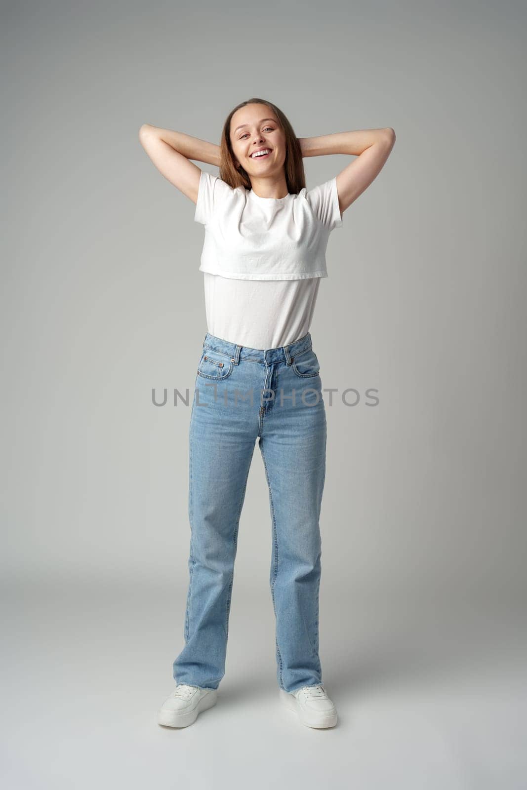 Young happy smiling woman on a gray background close up