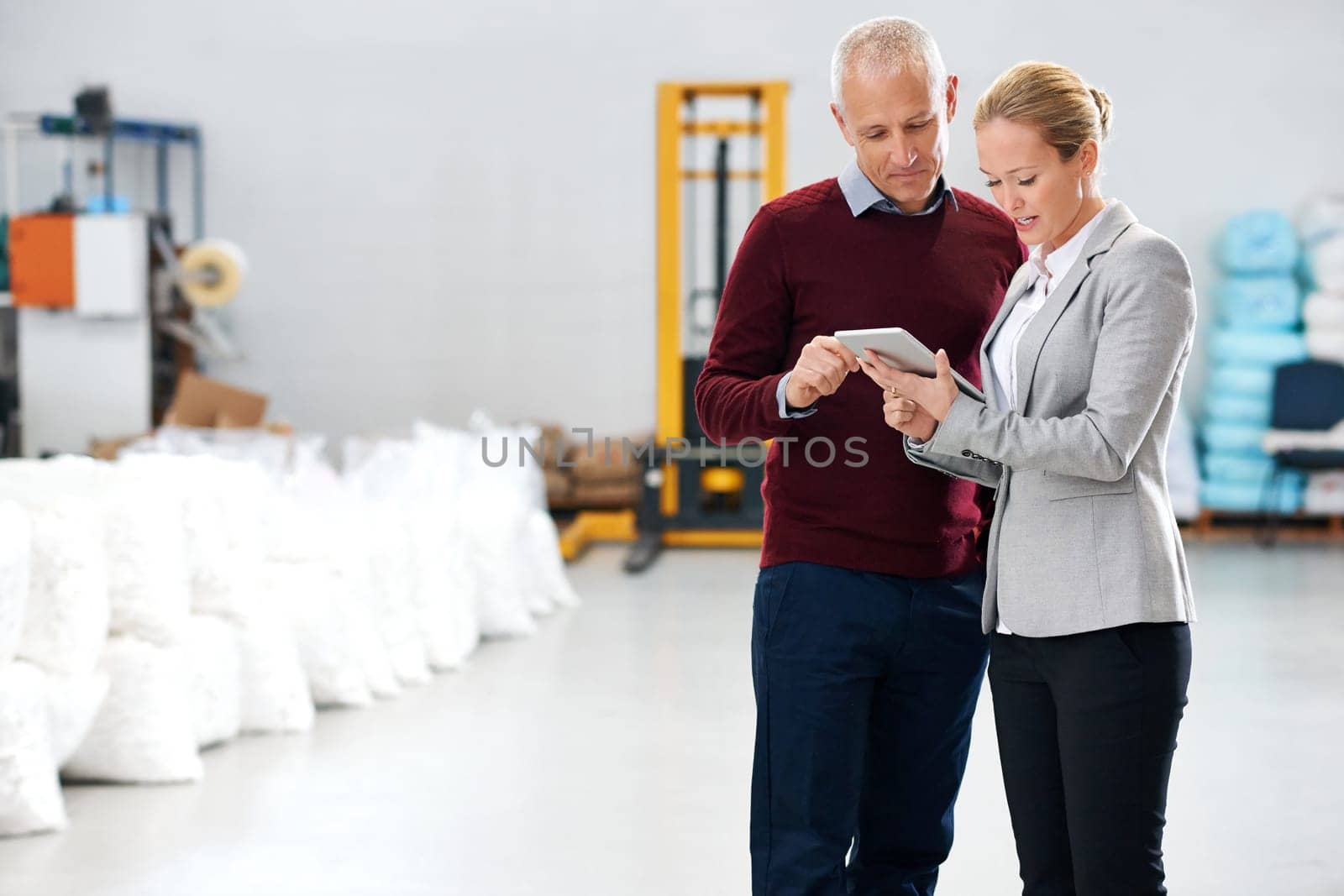 Logistics, warehouse and business people with tablet for teamwork, supply chain and ecommerce. Mature man, woman and discussion with digital technology for planning, communication or conversation by YuriArcurs
