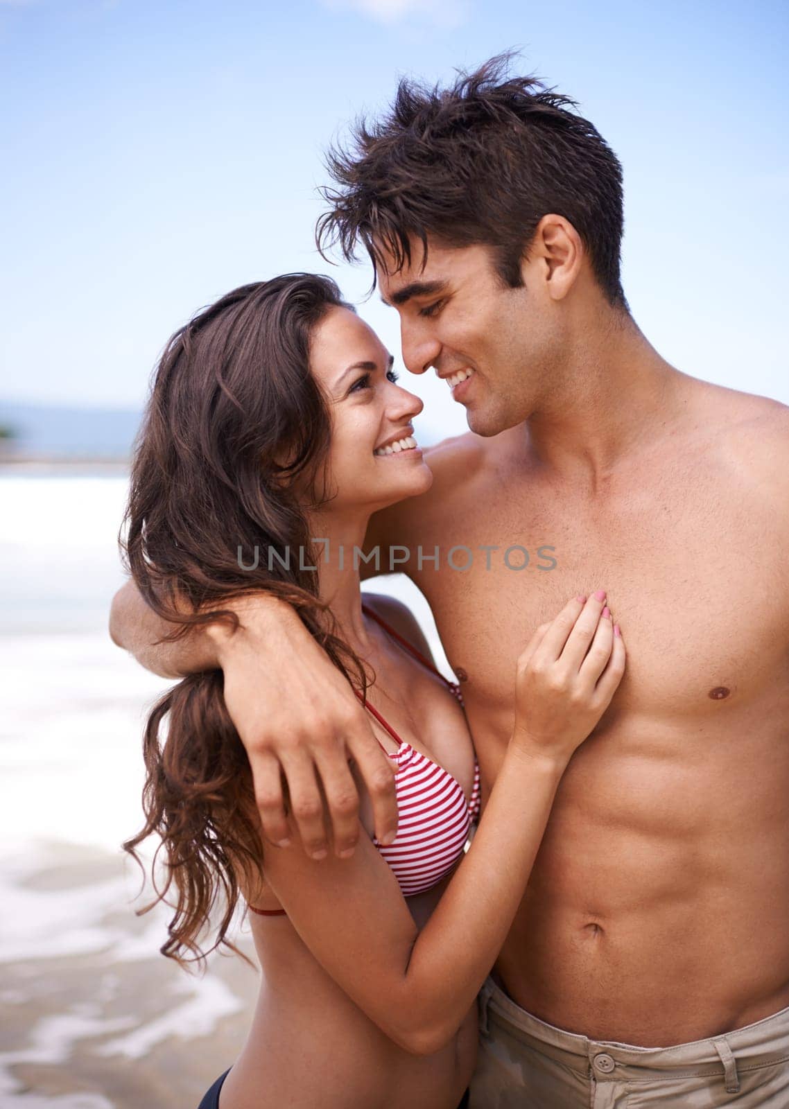 Beach, hug and couple with vacation, travel and weekend break for honeymoon and getaway trip. Outdoor, seaside and embrace with man and woman with holiday, smile or love with journey, ocean or summer by YuriArcurs