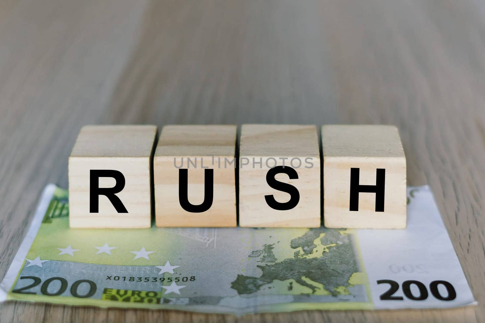 Rush word on a wooden cubes blocks, money 200 Euro banknotes. Management big salary career concept.