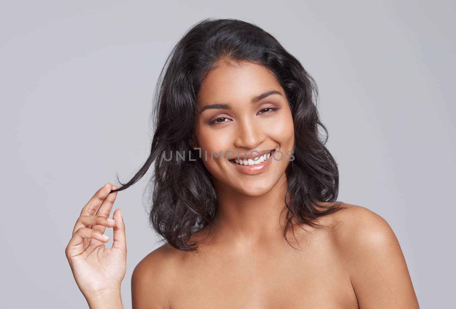 Happy woman, hair and portrait for beauty with cosmetics, salon treatment for texture and growth on grey background. Face, haircare and smile for shine, cosmetology and change with waves in studio.