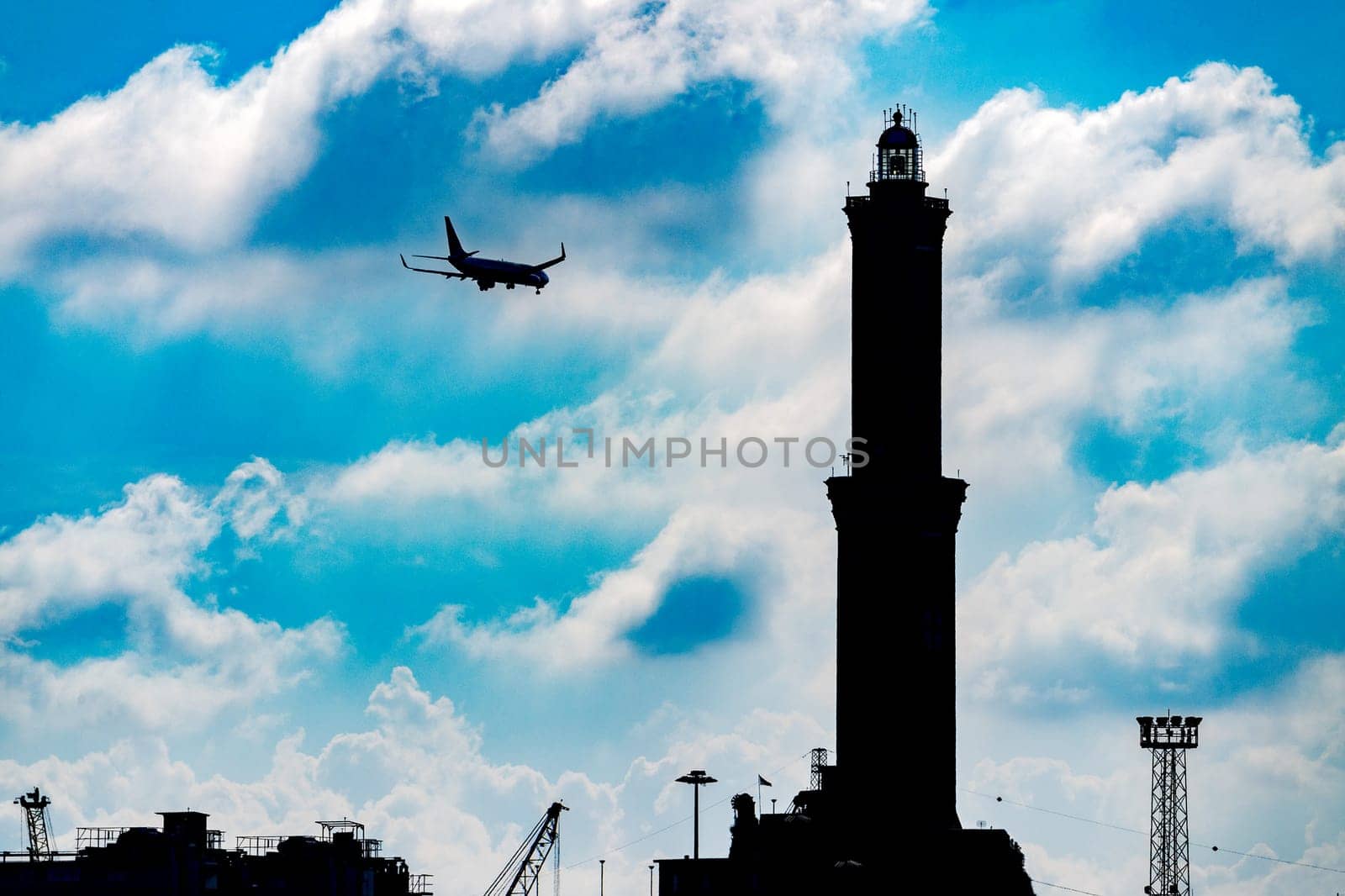 airplane before landing near  The Lanterna a lightouse in Genoa Italy Symbol in the sky background