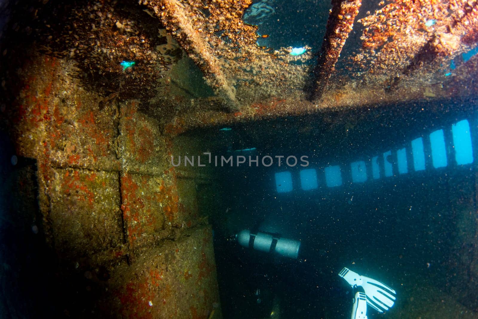 scuba divers exploring a shipwreck underwater