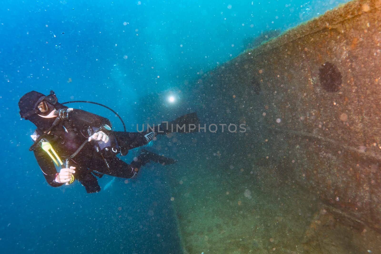 divers exploring a shipwreck underwater by AndreaIzzotti