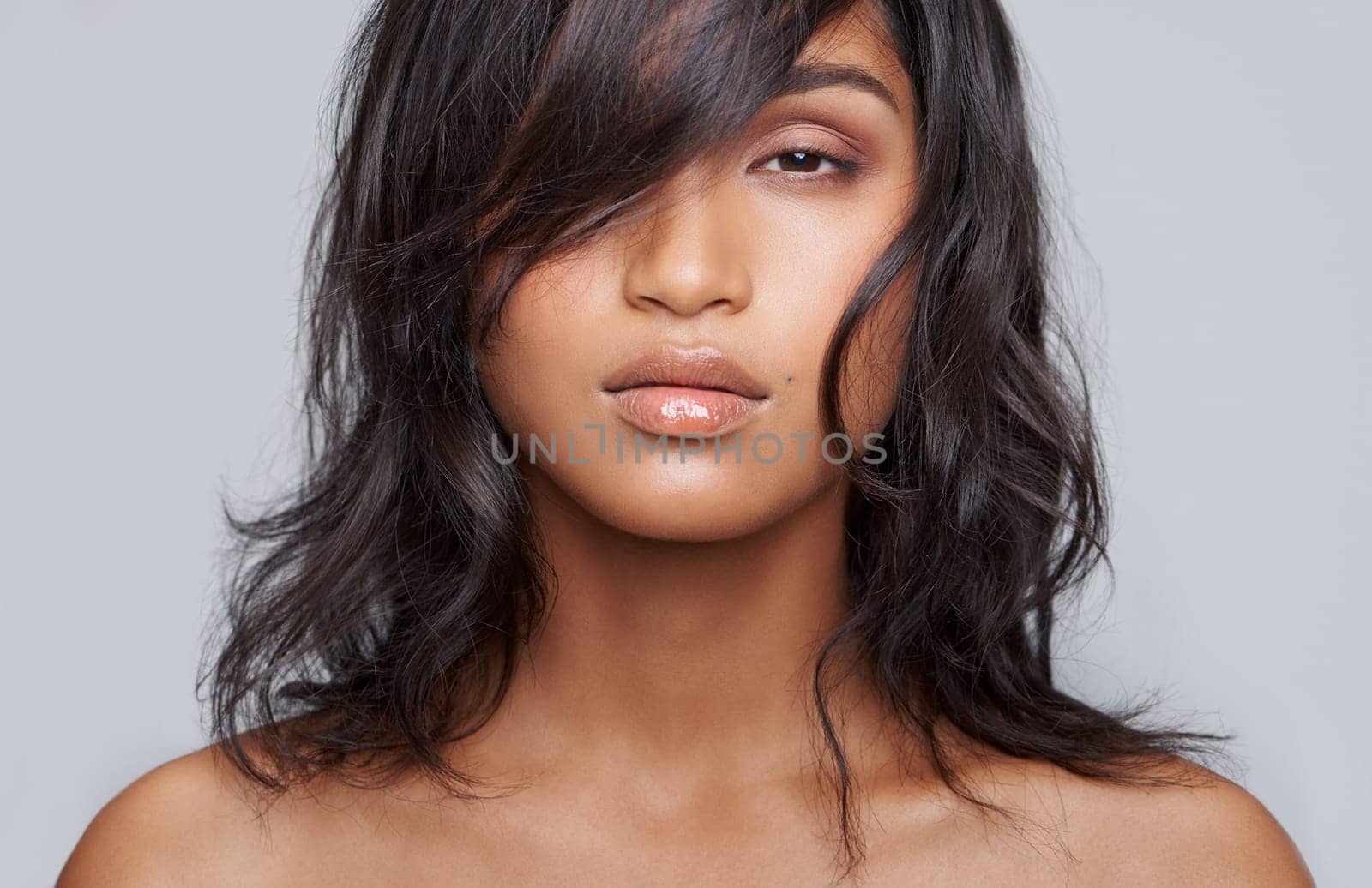 Woman, hair and face for beauty with hairstyle, salon treatment for texture and growth on grey background. Portrait, haircare and wellness for shine, cosmetology and change with cosmetics in studio.