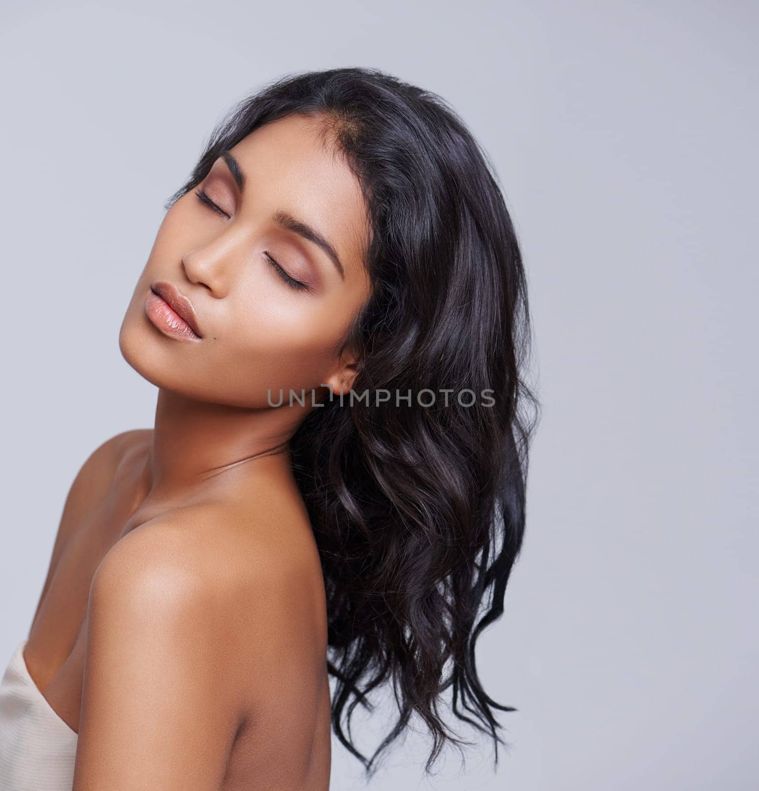 Woman, hair and texture for beauty with eyes closed, salon treatment for growth and cosmetics on grey background. Face, haircare and shine with calm, cosmetology and change with hairstyle in studio.