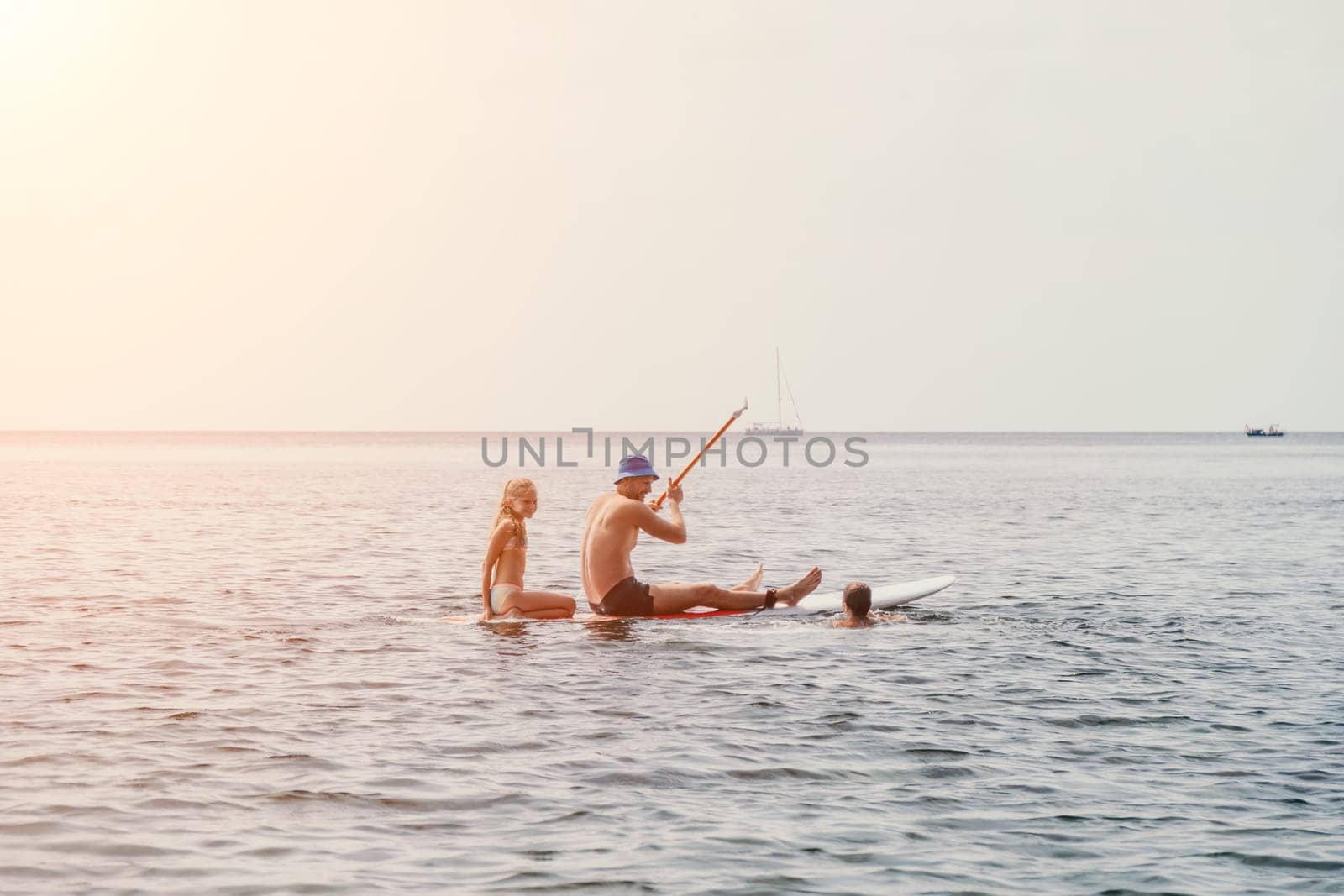 Family sea sup. Young happy father with his son and daughter Floating on a SUP board, paddling in blue sea water. summer vacation and Dad and Son Daughter concept. by panophotograph