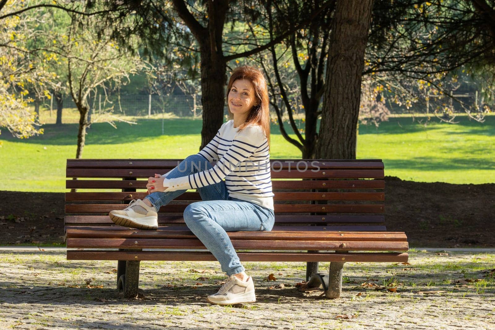 A woman is sitting on a park bench by Studia72