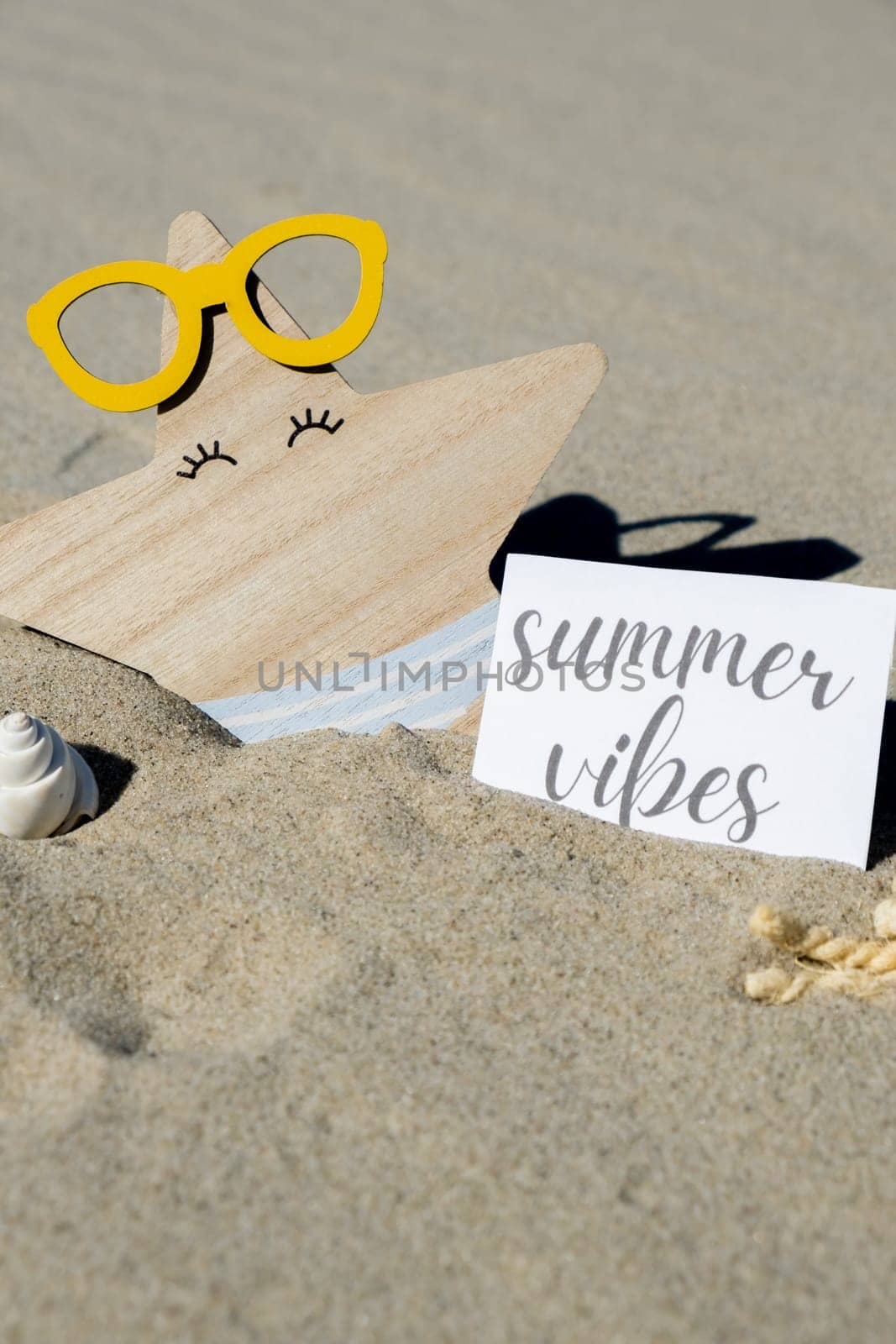 SUMMER VIBES text on paper greeting card on background of funny starfish in glasses summer vacation decor. Sandy beach sun coast. Holiday concept postcard. Getting away Travel Business concept