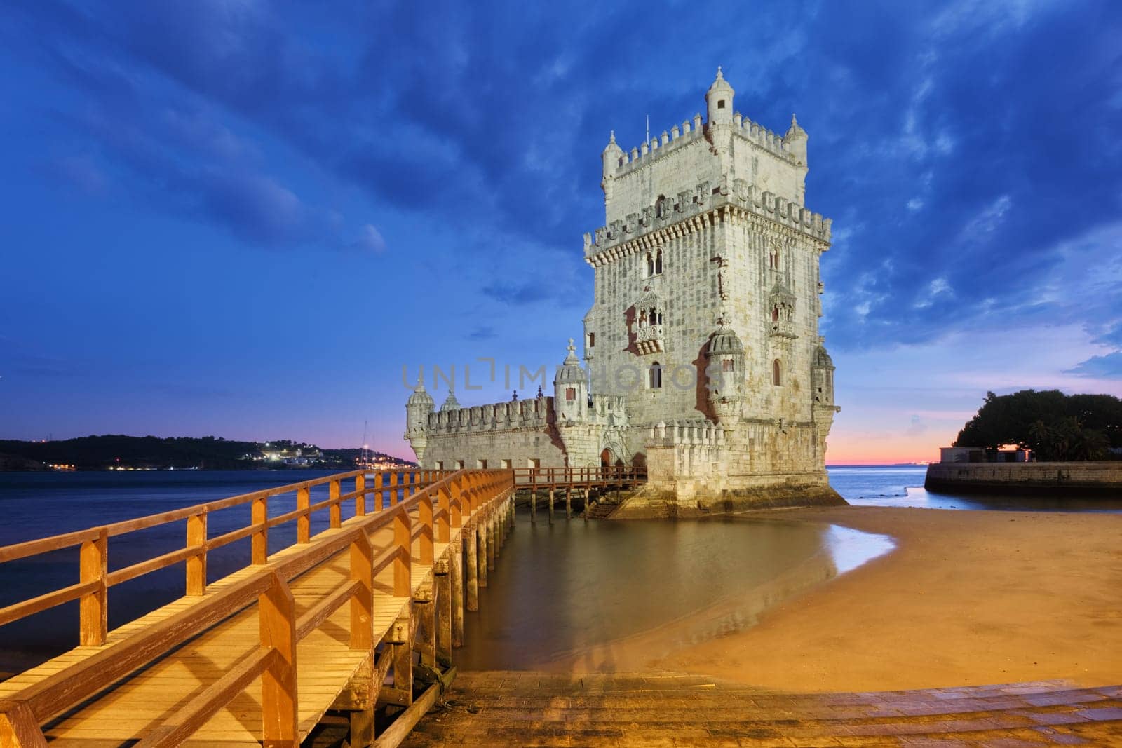 Belem Tower or Tower of St Vincent - famous tourist landmark of Lisboa and tourism attraction - on the bank of the Tagus River (Tejo) after sunset in dusk twilight with dramatic sky. Lisbon, Portugal