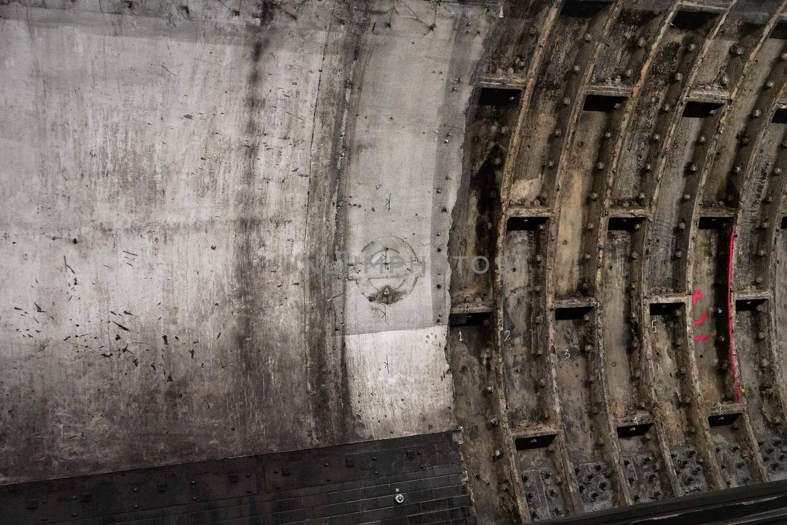 London, United Kingdom - February 02, 2019: Old dirty wall in tube train tunnel, missing London Underground logo on concrete by Ivanko