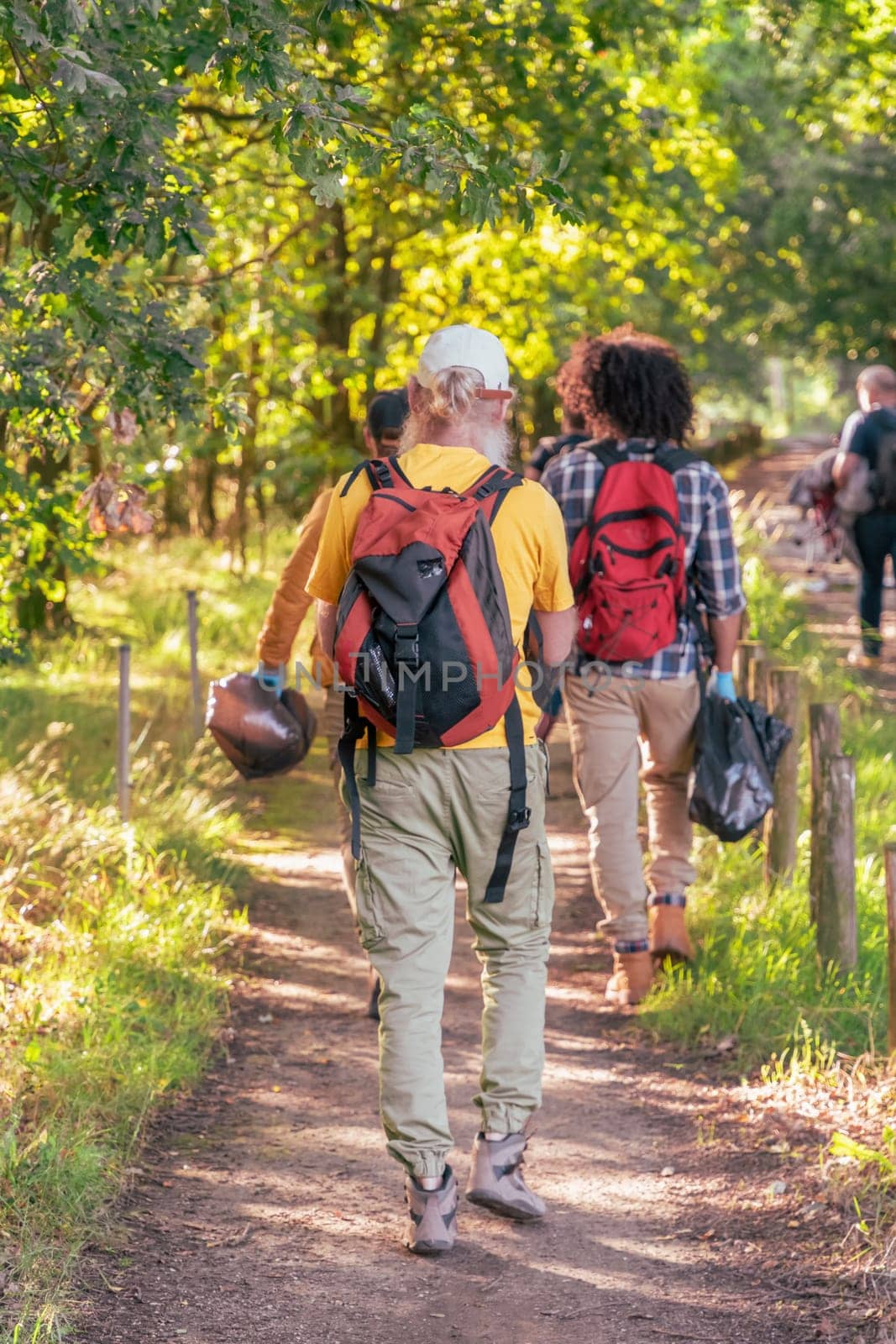 friends of different ages hugging together in nature against the backdrop of sunset celebrating a good walk together by KaterinaDalemans