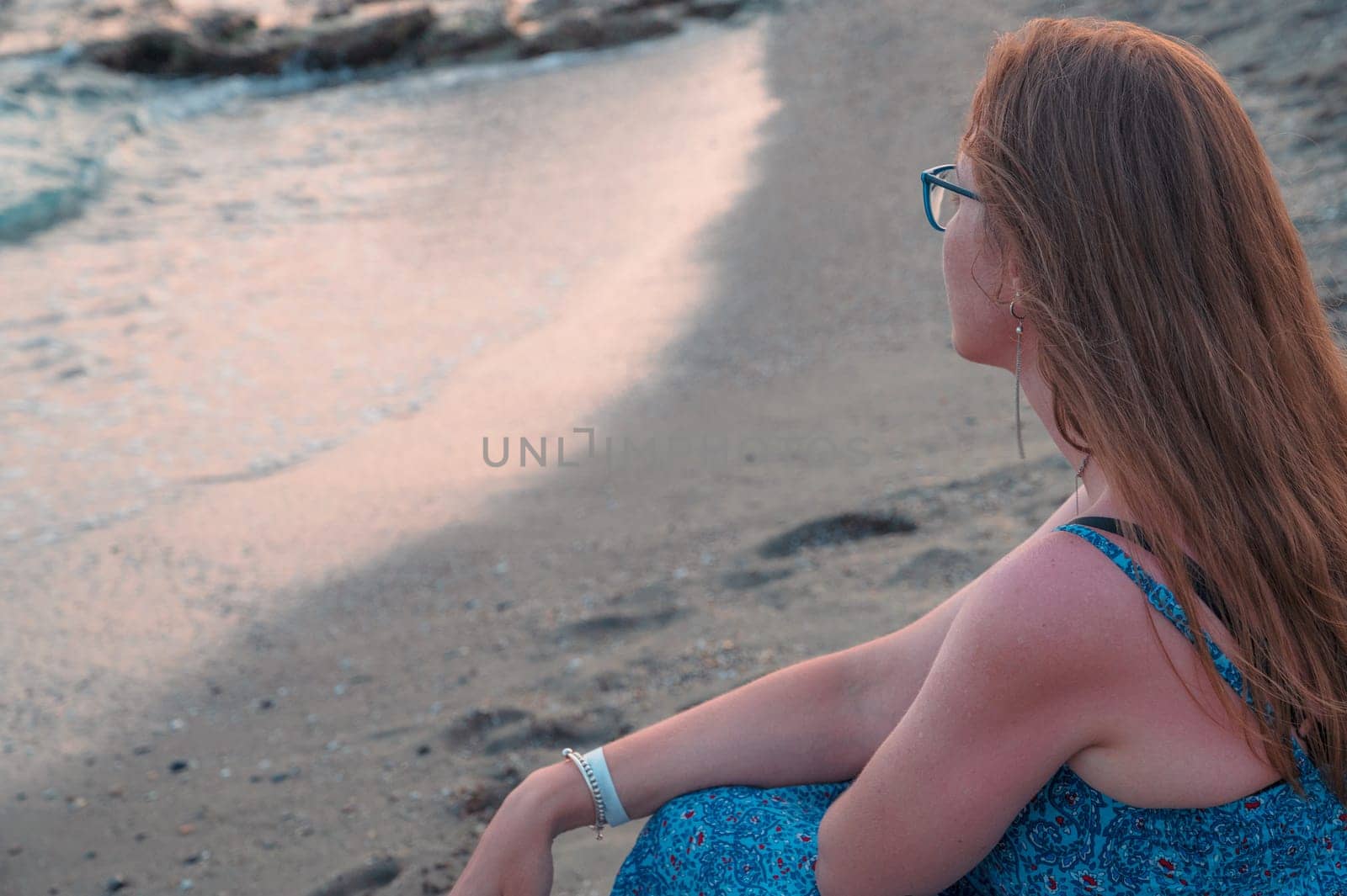 Woman sits on the beach and looks at the sea in Alanya city by rusak