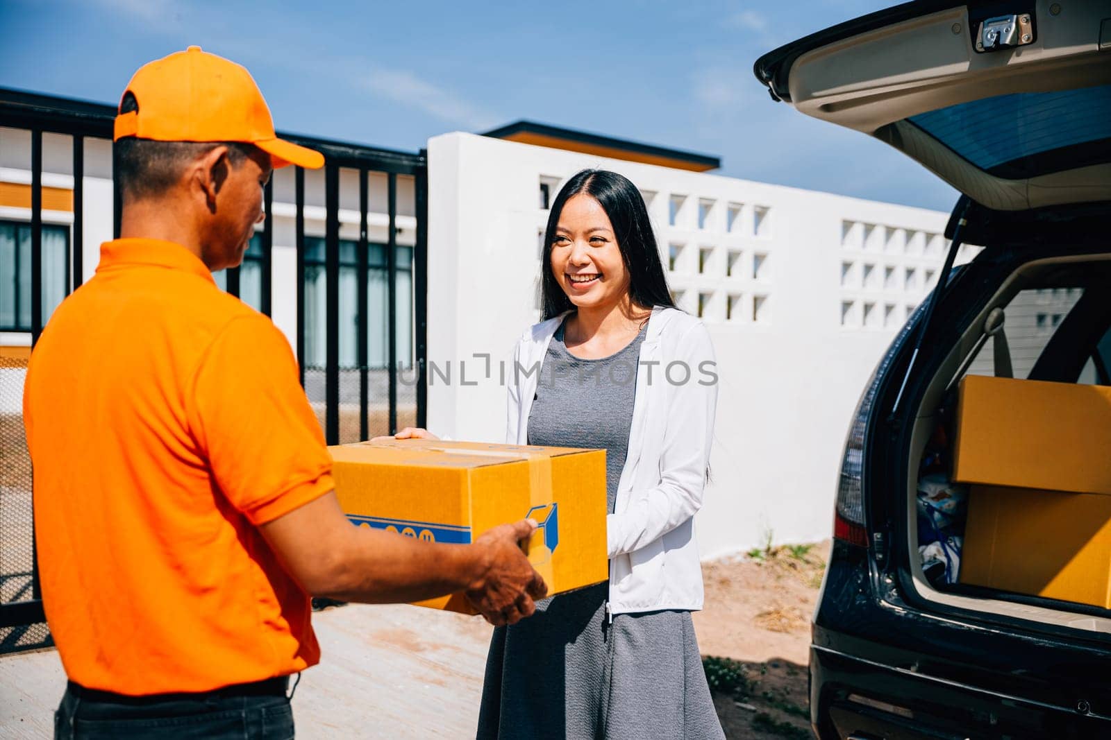 Efficient home delivery logistics depicted as a courier delivers a cardboard parcel to a smiling woman by Sorapop