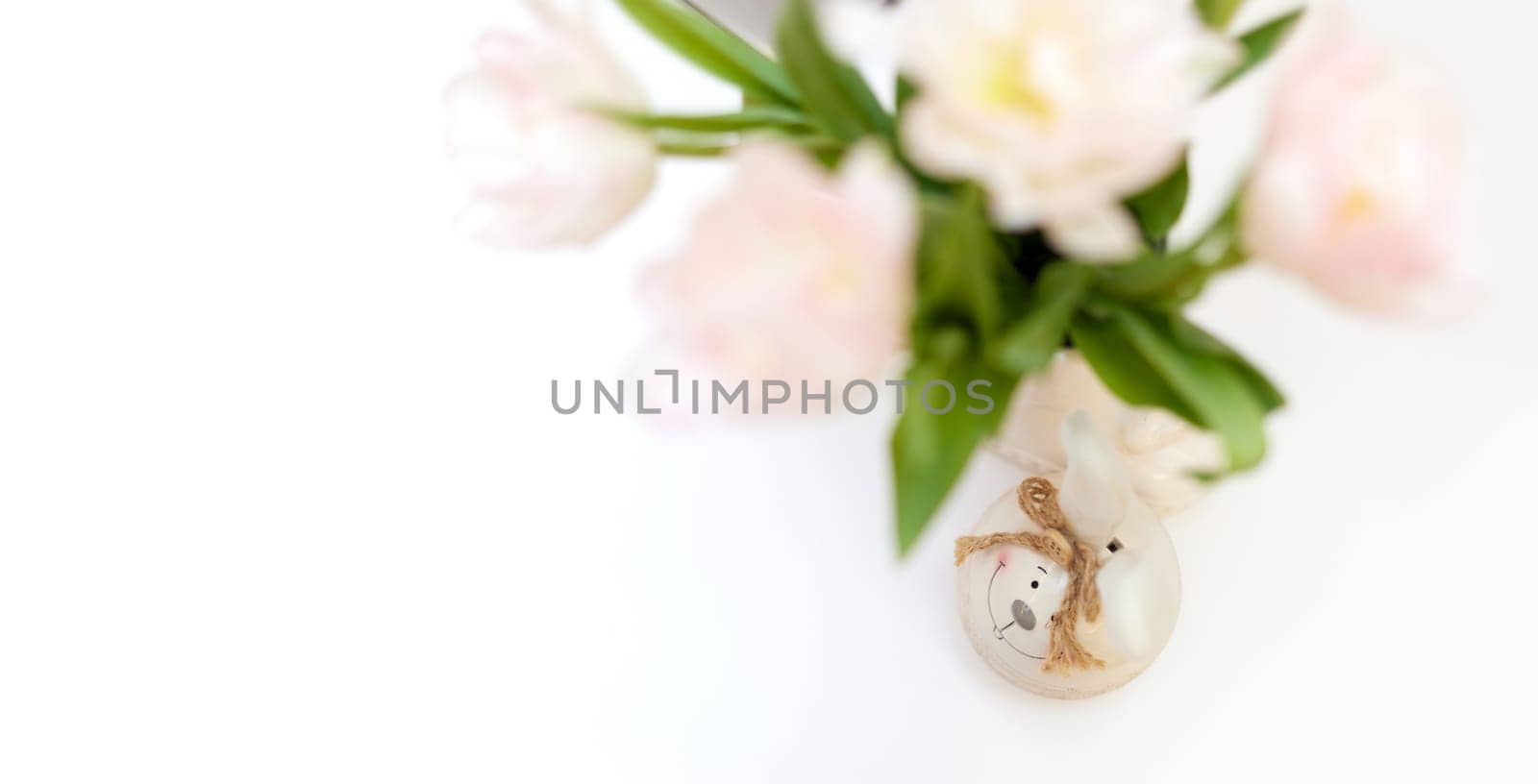 bouquet of tulips and Easter bunny on white table. copy space
