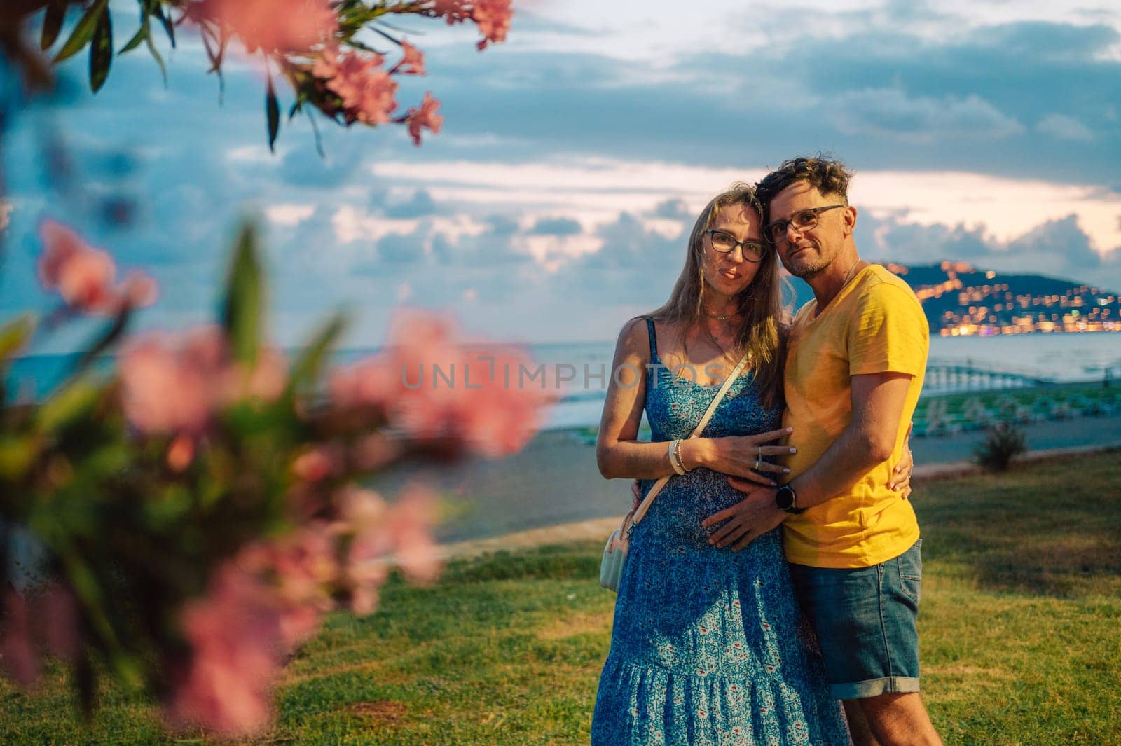 Happy couple taking a photo on a beach at the sea in Alanya city, Turkey. Focus on the background. Travelling or vacation concept